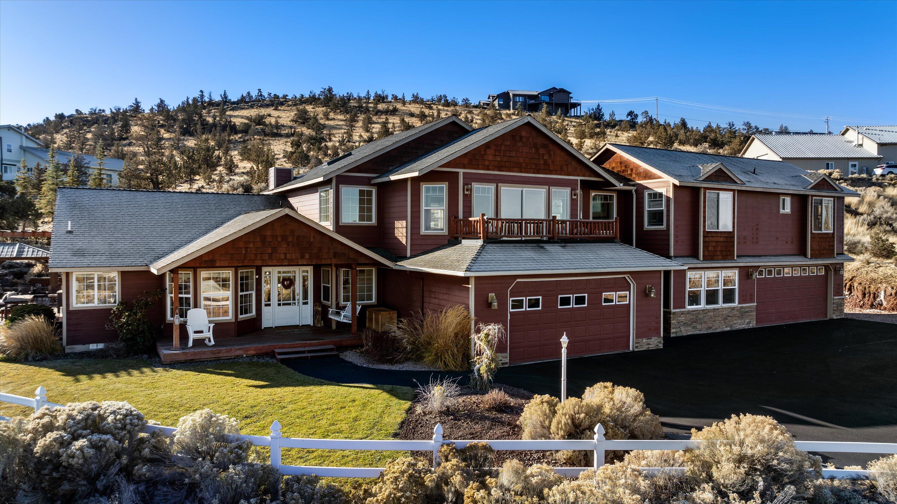 Welcome to 1710 NW Kesley Lane, where the beauty of Central Oregon unfolds right outside your front door. Enjoy expansive views of Smith Rock, Mt. Hood, and Mt. Jefferson from the front of the house, or while entertaining guests beneath the custom pergola on the Trex deck, complemented by the newly installed outdoor patio with a BBQ and fire pit. This spacious 6-bedroom, 4 bathroom home includes two primary suites, one conveniently located on the main level and another upstairs, updated bathrooms, comfortable living spaces, and two 2-car garages, one of which could be used as storage for your toys, or converted into a workshop. There is a 1500 gallon cistern which is connected to a shared well under the Circle C Improvement District at $65 a month and RV parking + hookup on the side of the house. This income-producing property is currently used as an Airbnb part time, with potential for even greater returns as a full-time vacation rental.
