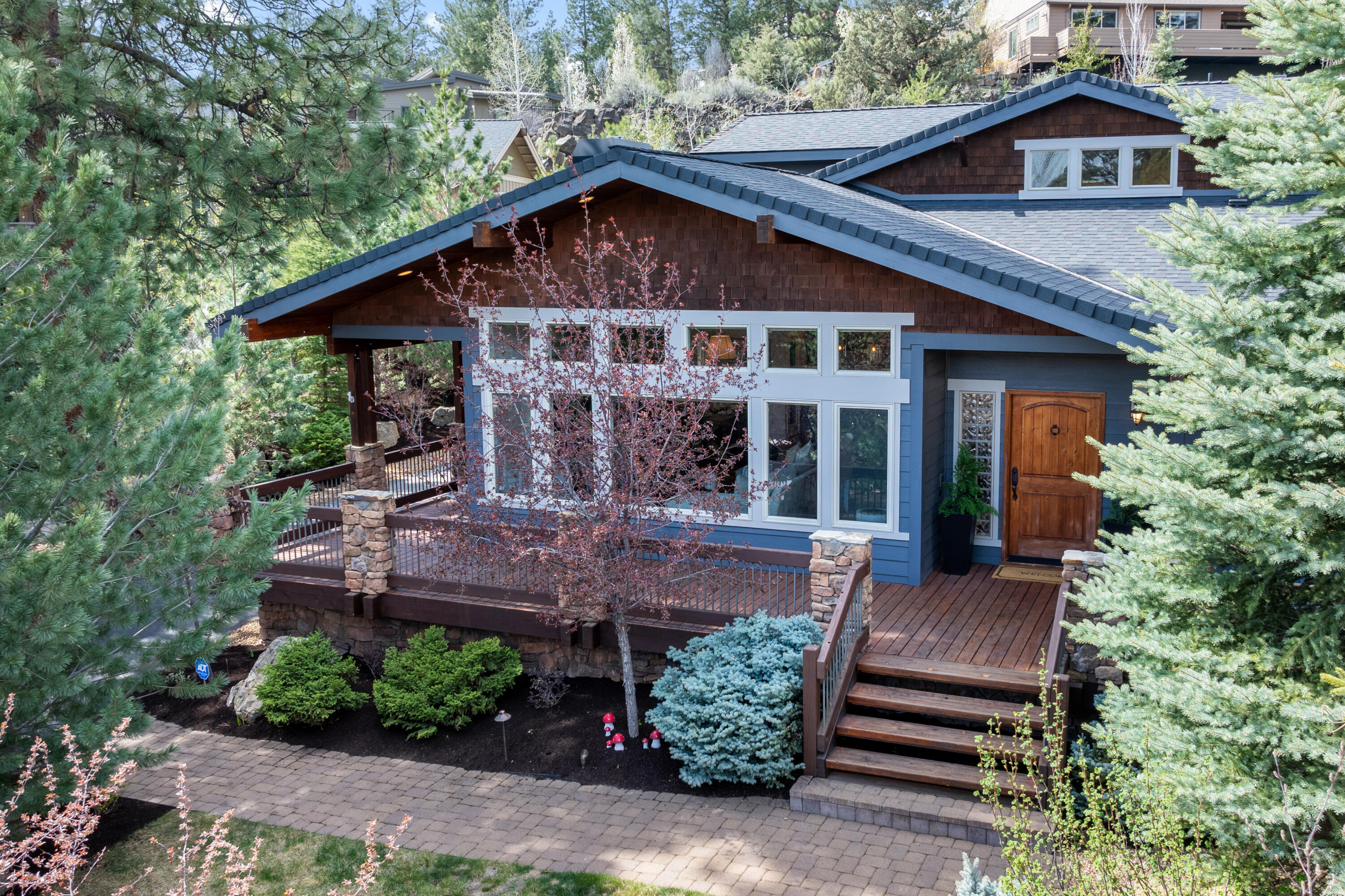 Streaming through a wall of south facing windows, natural light floods the great room of this Shevlin Ridge home, highlighting wood lined vaulted ceilings, floor to ceiling stone fireplace and a center island kitchen with plentiful storage & 6 burner gas range. Perfectly sited back off the street & screened by many mature trees, this home enjoys an enhanced sense of privacy, taking full advantage of the large .39 acre lot. The main level includes a light-filled private office just off the entry & a primary suite anchored by a large bath with dual vanity, jetted tub & full tile & stone shower. Upstairs, 2 bedrooms, 2 full baths & a vaulted bonus room with extensive storage and multiple skylights. Enjoy year round outdoor living on the large covered deck with access to a beautifully landscaped, fully fenced backyard with stunning, year round waterfall & large paver patio. With a wrap around deck & enclosed under deck gear storage, this is the perfect base camp for your Bend adventures!