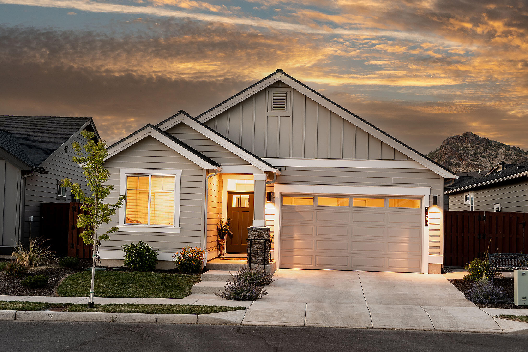 Discover this nearly new single-level home with inviting southern exposure. An open floor plan seamlessly connects the stylish kitchen—complete with eating island and dining area—to a vaulted great room that features a gas fireplace and tall sliding doors, flooding the space with natural light. Step outside to enjoy a spacious covered patio with peek-a-boo views of Barnes Butte, perfect for relaxation or entertaining. The front bedroom has ensuite access to a full bath, while upgrades include a primary suite door leading to the patio, a garbage bin in the kitchen island, under-cabinet lighting, solid wood shelving in the pantry and closets. Highlights include full-height tile backsplash, tiled shower in the primary suite, & AC for year-round comfort. This vibrant community boasts excellent amenities such as parks, a swimming pool, a picnic pavilion, a children's playground, and a half sports court, along with a scenic pathway leading to Prineville's Barnes Butte public walking trails.