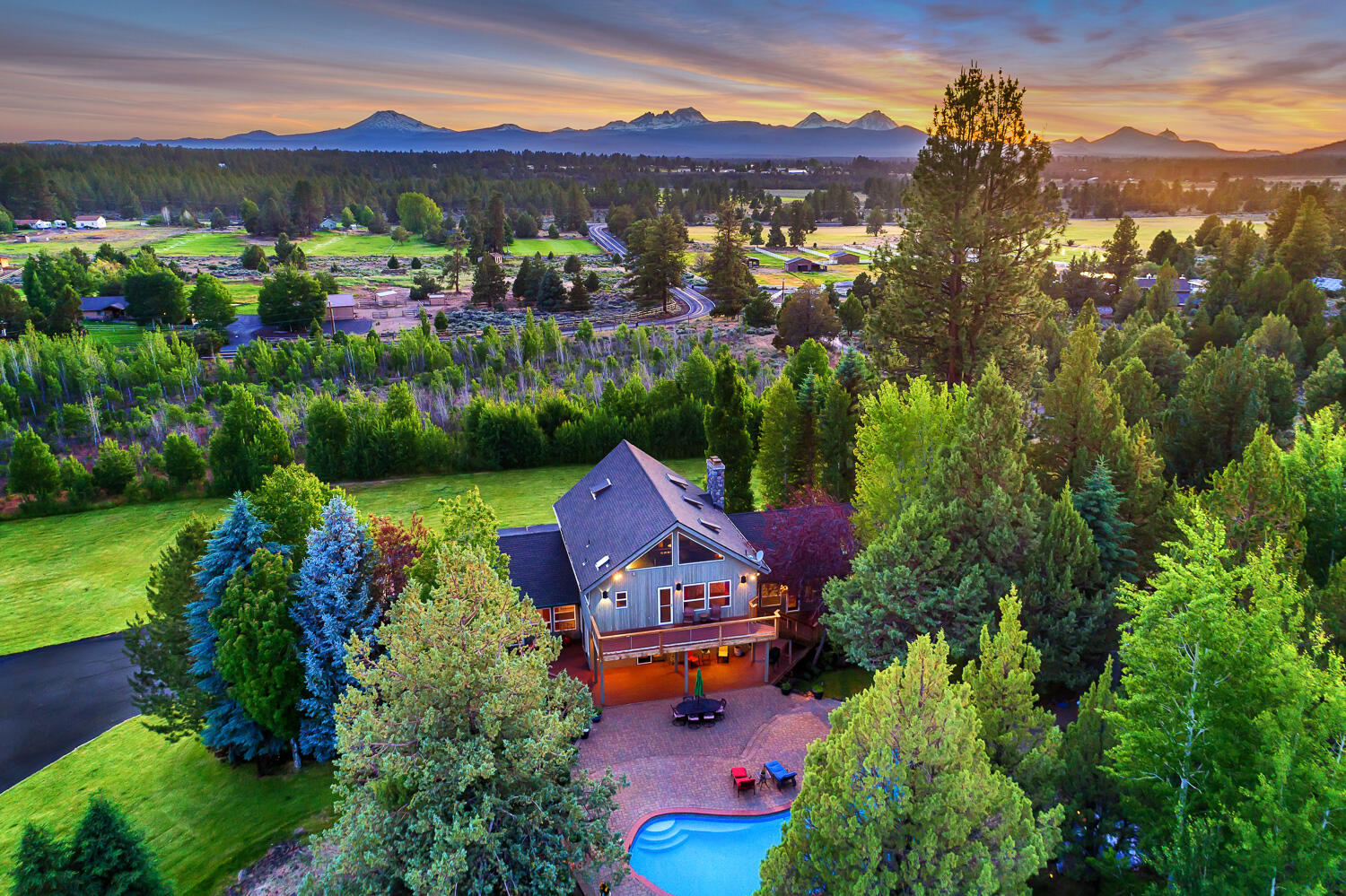 Seller credit of $30,000 with acceptable offer! This estate offers a stunning home with Cascade Mountain views, a refinished pool, a shop with guest quarters & RV parking, a barn, and irrigation. Step into the lower level family room, bonus room & full bath. Upstairs, the great room features an impressive stone fireplace, vaulted ceiling, and floor-to-ceiling windows showcasing panoramic views. The kitchen with island seating and a sunlit dining area opens to the back deck. The main floor also includes two en suite bedrooms, two additional bedrooms, and laundry. The primary suite upstairs boasts remarkable views & a private deck overlooking the pool. The extensive shop with a guest house has a separate bay with RV hookups, addl. shop space or parking, kitchenette, 2 bedrooms, full bath & office/flex space. Horses and goats thrive in the barn and pastures. The pool, surrounded by extensive pavers, is the focal point of the backyard, ideal for lounging and entertaining