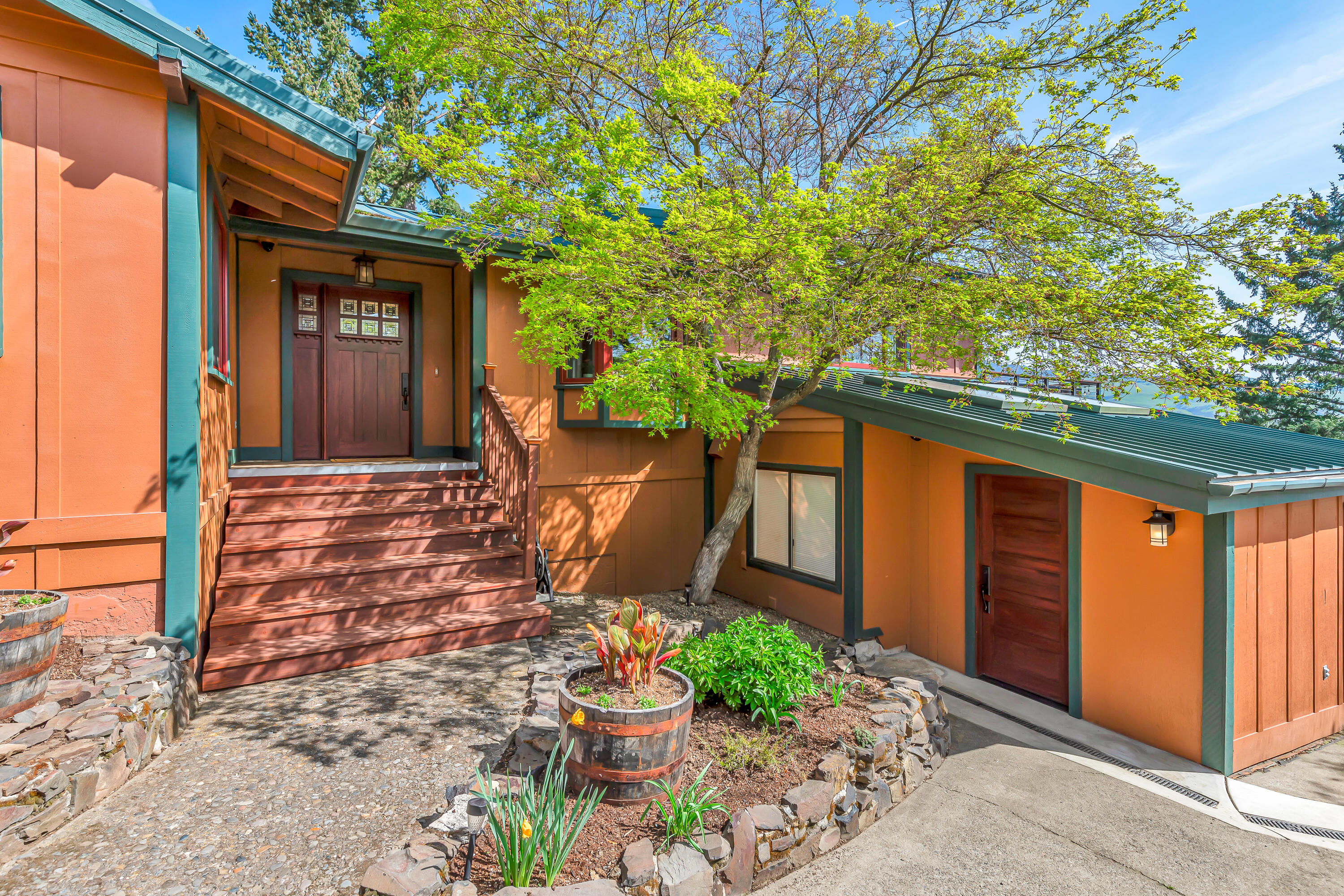 Updated view home above the boulevard near Asante Ashland Community Hospital, just four minutes from the plaza and Lithia Park! Tiled entry and formal dining with two wine refrigerators and built-in buffet, gourmet kitchen with radiant heated floor, stainless appliances including two Wolf ovens, six-burner cooktop with griddle, two dishwashers, and pantry with second refrigerator. Vaulted great room with exposed beams, river rock fireplace with wood mantle, and sliding glass door to refinished redwood deck with panoramic mountains and valley views. Three main-level bedrooms and two full bathrooms including primary with walk-in closet and full ensuite bath with radiant-heated floor, double vanity, and tiled shower. Lower level with new carpet in fourth bedroom or office and spacious family media room, half-bath, gym with washer dryer hookups, plus a 300+ SqFt bonus room with two skylights suitable for workshop or potential guest quarters with exterior entrance. Inquire for details!