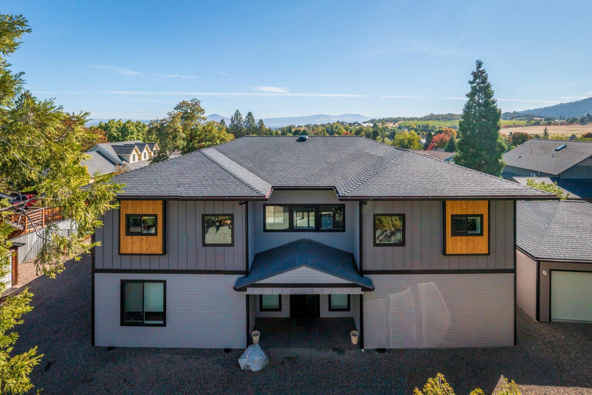 Experience contemporary living in this exquisite home with guest house on a large, wonderfully located lot, in historic Jacksonville. Be swept away with 4,192 sq.ft of modern finishes, split floor plan featuring 4 bdrms/5 bth; 3 of which are en-suite with walk out balconies with valley/vineyard/mtn views! Amazing entry to living room with 21 ft. ceilings, gas in-wall fireplace with floor to ceiling wood accents from The Historic Cardwell House. Main room windows and shades are remote control and compliment the powered telescoping sliding glass door. Two tone quartz counters, soft close cabinets, black stainless steel appliances, large breakfast bar & wine fridge! Oversized pantry and laundry area, spacious office plus a theatre room. Upstairs primary bath has heated floors, soaking tub, walk in shower, gigantic closet with private laundry. Main home and Guest home each have 3 car garage! Fire suppression system, custom tile and LED lighting throughout! 3 blocks to shopping & dining.