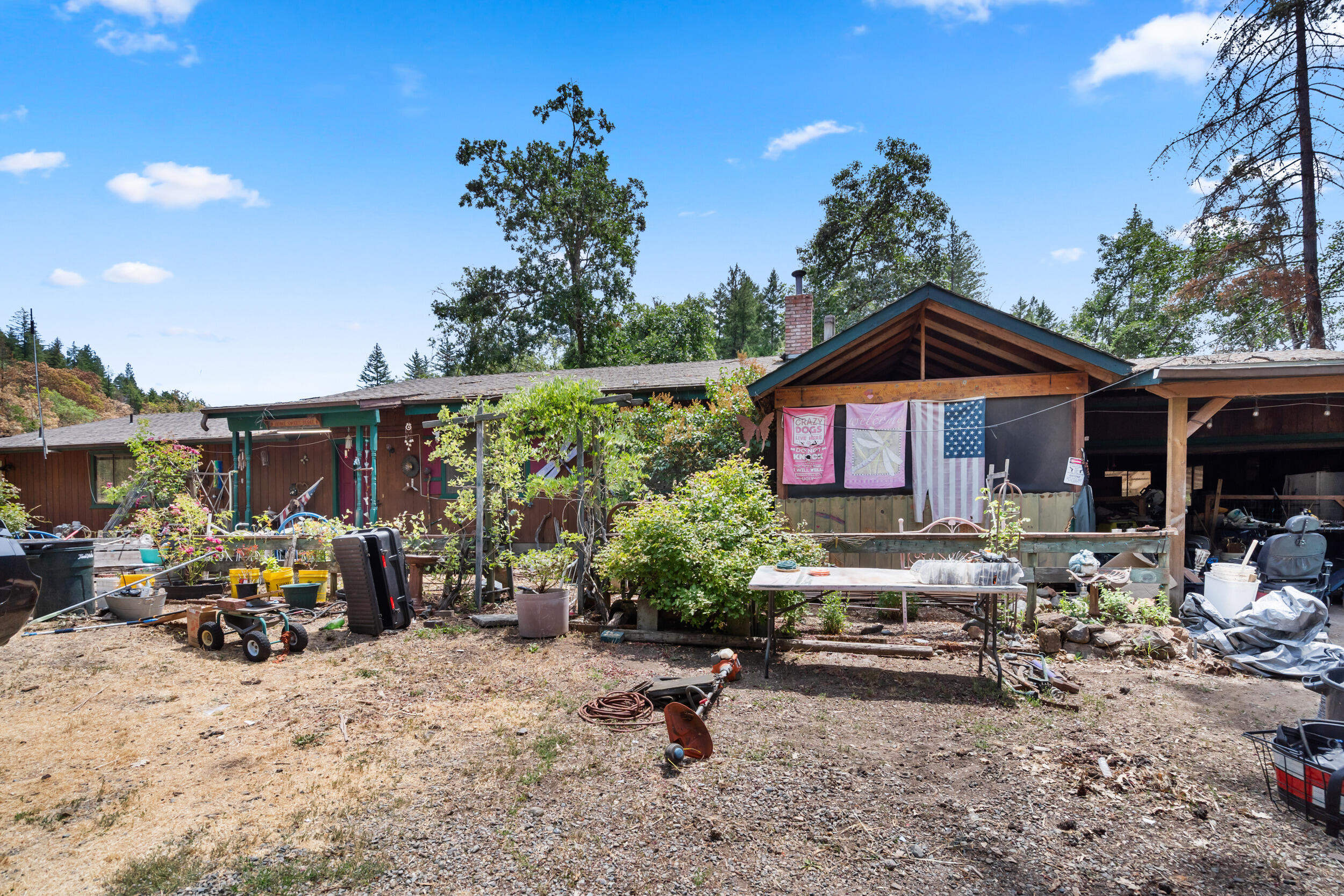 Incredible opportunity! Two parcels totaling 23 acres just minutes from Cave Junction. The main 5-acre lot features a 1,848 sq ft single-level home with vaulted, beamed ceilings, wood flooring, and a fireplace for cozy evenings. The spacious kitchen includes a skylight, generous storage, and flows into the dining area with wood floors and sliders to a 425 sq ft deck. The primary bedroom offers two private bathrooms—one with a tiled walk-in shower, the other with a soaking tub—and a walk-in closet. There's also a second bedroom, a third room for office or bedroom use, plus a guest bath. Outside: 4-car garage, carport, enclosed porch, and plenty of open space. The second parcel provides 18 private acres with Forest Commercial zoning—ideal for forestry, recreation, or possible development. Enjoy rural living close to dining, shopping, and hiking trails. Live, work, or invest—this versatile property has it all!