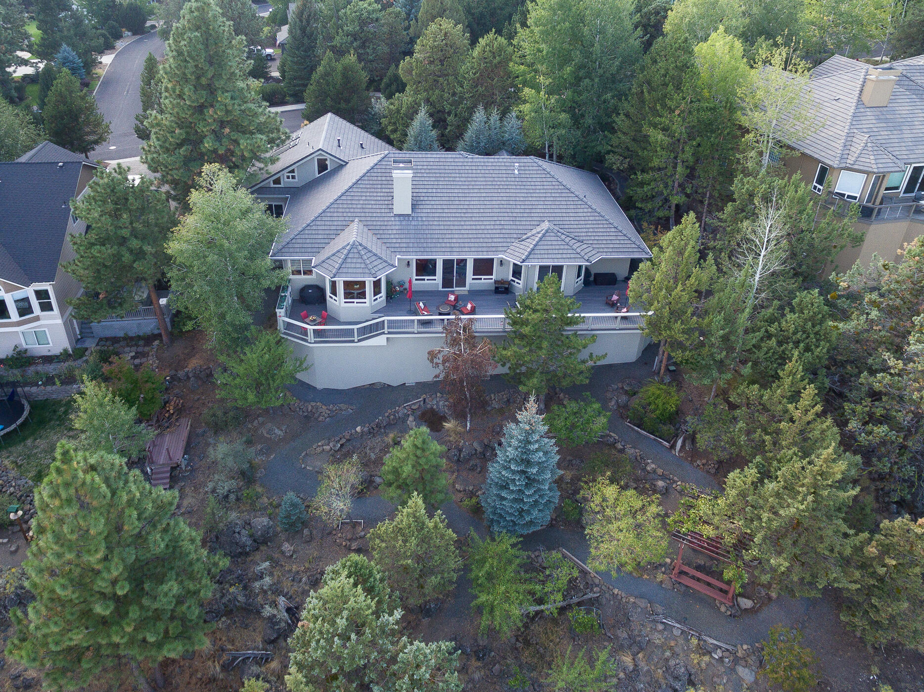 This timeless Awbrey Butte home boasts sweeping Easterly views, showcasing the vibrant City of Bend, Pilot Butte & Smith Rock. Enjoy the gorgeous Central Oregon sunrises from the spacious deck overlooking the terraced yard and garden area as well as native landscaping. Welcoming covered front porch. The incredible chef's kitchen will not disappoint, white cabinets, a large grey island topped with stunning leathered quartzite and hardwood floors. Corner sink with abundant natural light. The vaulted great room features a double sided full rock fireplace, formal dining, breakfast nook and wet bar making this home an entertainers delight. Main level primary with hardwoods and a lovely remodeled bath and large walk in closet. Three more guest rooms, one currently being used as an office. Upstairs is a large private suite with full bath, this would also make a wonderful media room or home office. Loads of storage, flat driveway, 3 car garage with epoxy flooring. Definitely a must see!