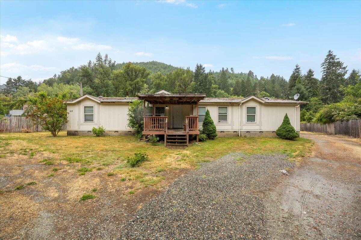 Discover peaceful country living at 513 Barton Rd in Glendale. This 2007 manufactured home sits on 1.76 acres with a permanent block foundation and plenty of space inside and out. It features 4 bedrooms, 2 full bathrooms, and a large bonus room off the primary bedroom that works great as a home office, reading nook or craft room. The kitchen is oversized with tons of cabinetry and a pantry, and the layout includes two living spaces plus an indoor laundry room. Step outside and enjoy the open land, an oversized detached 2-car garage, and scenic views of the trees and hills around you. Middle Cow Creek runs along the back of the property, bringing a peaceful, natural feel to the space. Whether you are relaxing near the creek, planting a garden, or setting up for animals or toys, there is room for it here. Propane is already connected and I-5 is just moments away, giving you the best of both quiet country living and fast access to town. This one is ready for you to make it your own.