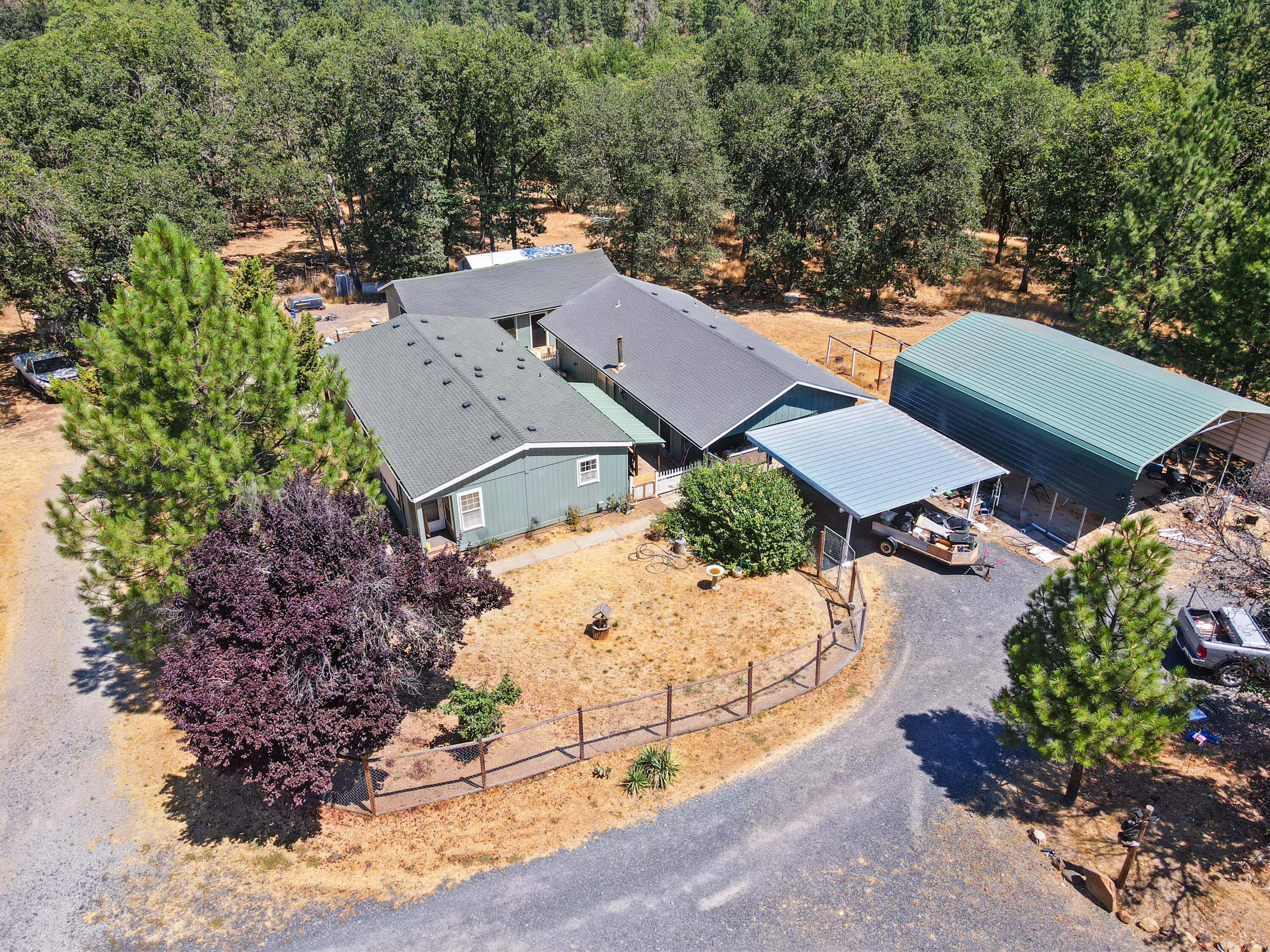 GOLDEN CHANCE IN GOLD HILL! Discover countryside bliss on 5 serene acres with not one, but TWO homes. The newer gem is a 1994 manufactured, offering modern comforts amid rustic charm. Plus, the vintage 1964 charmer—a cozy 2-bed, 1-bath —currently moonlights as a spacious storage haven. But wait, there's more! A collection of outbuildings awaits exploration, including a roomy shop, a COLOSSAL RV carport that fits two RVs, and a detached 2car garage with a cozy office/workroom/bedroom—perfect for a home business. Animal lovers, rejoice! There's a chicken coop, and plenty of space for livestock, gardening, or equestrian. Imagine a seasonal creek meandering behind the property, whispering tales of gold panning adventures. With a garage, TWO carports, and ample room for RVs, this property is a haven for vehicles & gardeners with the 11gpm well. Whether you're dreaming of homestead or a retreat from the hustle & bustle, this property invites you to explore its beauty AND opportunity!