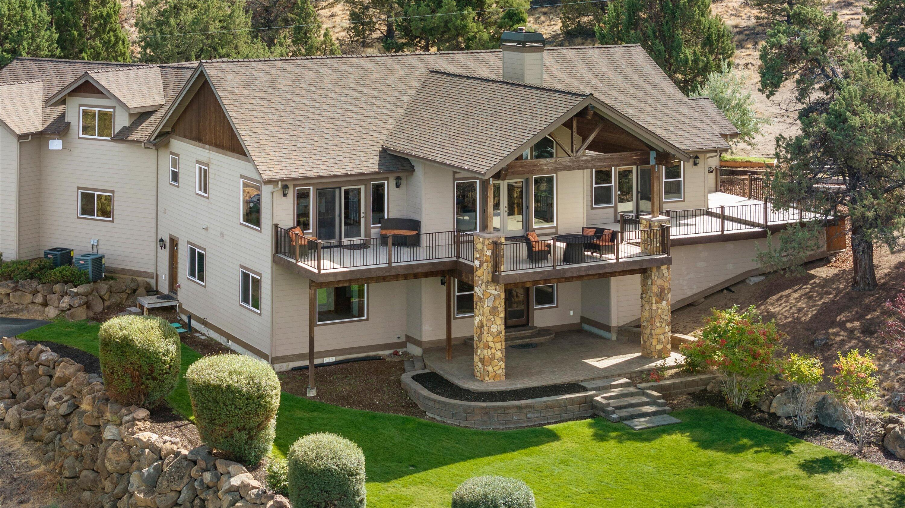 Enjoy awe-inspiring panoramic Cascade Mountains and Smith Rock vistas from virtually every room in this exceptional Northwest craftsman home, nestled near Tumalo. Situated on three private acres, the property borders 120 acres of public land. This meticulously crafted retreat encompasses five bedrooms, four full bathrooms, and a media/family room with a wet bar and double-door access to a generous patio and yard. Additional amenities include a wine cellar, multiple outdoor living spaces, and an expansive covered deck for year-round entertaining. An oversized three-car garage, a 1200-square-foot detached shop with power and water, and an RV parking spot with full hookups complete the property.