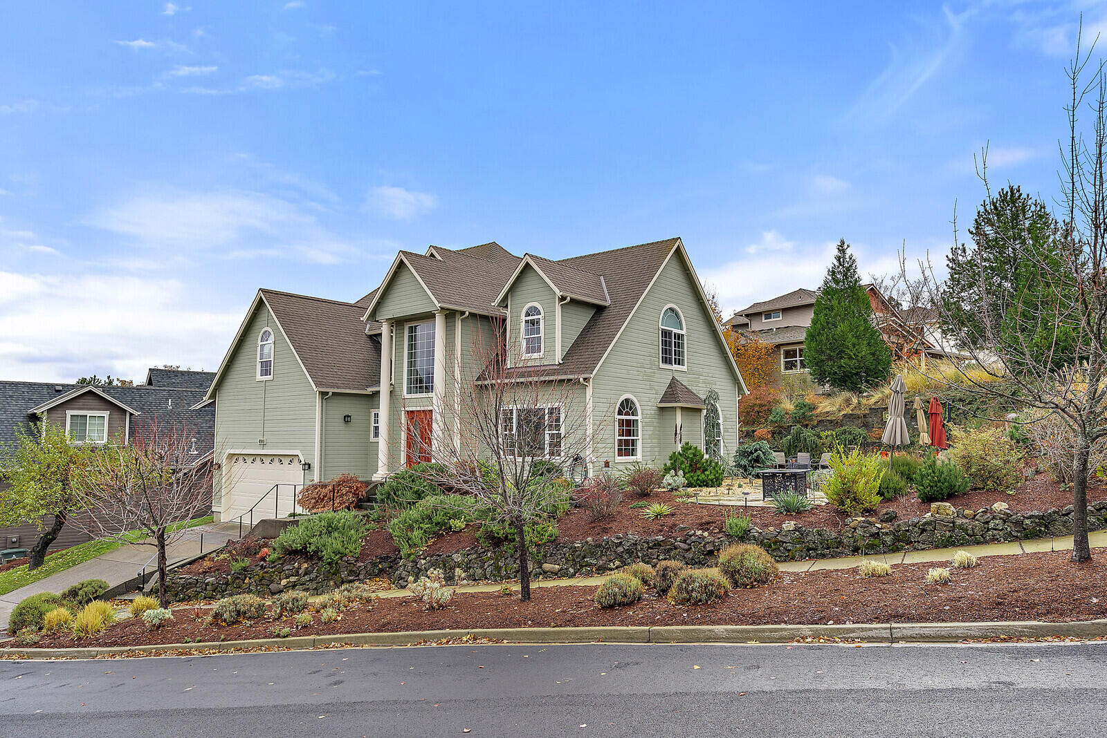 Beautifully designed to capture views of the vast mountain range and valley, this 4 bedroom 2.5 bath home is spacious and elegant. Impeccably maintained and filled with natural light this home offers it all. Soaring ceilings invite you into the living room where a gorgeous slate gas fireplace awaits. The kitchen boasts slab granite counters, stainless steel appliances and access to the private backyard and gardens. The Main level master invites ease of living w/ a dual vanity and jetted bathtub for soaking. Upstairs you will find another master w/2 additional large bedrooms. The upstairs master has an added sitting room w/ large arched windows framing the Cascade Mountains and Grizzly Peak. The outside gardens are fully landscaped w/timed irrigation & solar lights guiding you along the stamped concrete pathway to the many sitting/eating areas, each selected to artfully take in the views. A deer proofed rose garden and gas fire pit complete the outdoor ambiance. Attached two car garage.
