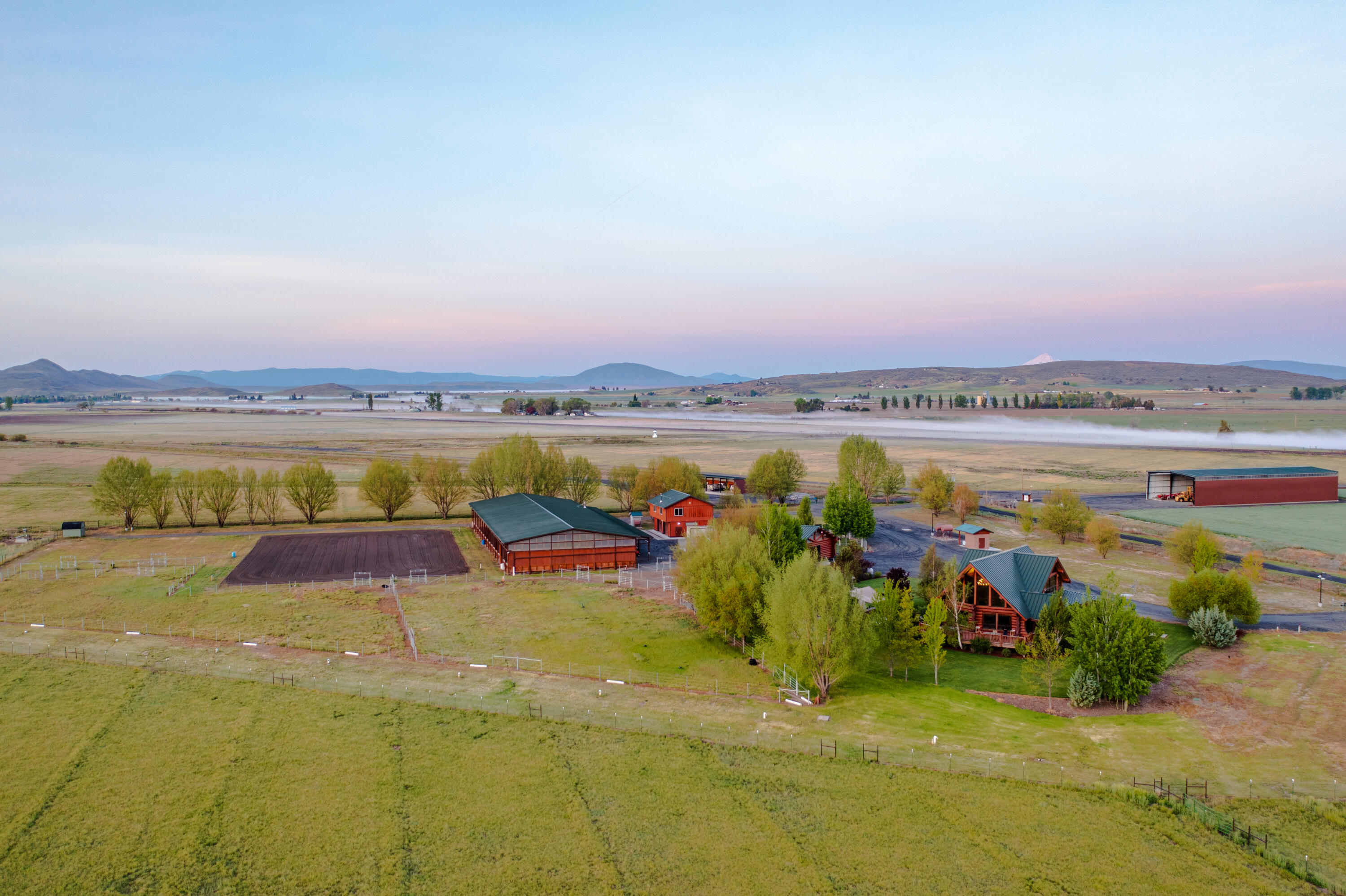 Welcome to Lighthouse Ranch, nestled against the backdrop of Stukel Mountain, just south of Klamath Falls. The custom hand-fit non-chinked red cedar Pioneer Log Home captures the comfort & warmth of the Pacific Northwest. This stunning property allows you to enjoy a refreshing rural lifestyle, expansive equestrian opportunities, charming small-town culture, & a valley setting that offers the best of Southern Oregon, with spectacular views. The 128+ acre property encompasses over 50 acres of flood irrigated pasture & not to mention your own 1300ft airstrip north of the home. A 15-bed state-of-the-art greenhouse, a 2 car detached garage with additional living quarters, 9000 SqFt hay cover, a 2400 SqFt machine shed, and other smaller outbuildings. Touring the property, you will also find a 1,920 SqFt custom 4-stall stable barn, an Olympic style 13,600 SqFt covered arena w/ an adjoining .5-acre outdoor arena.