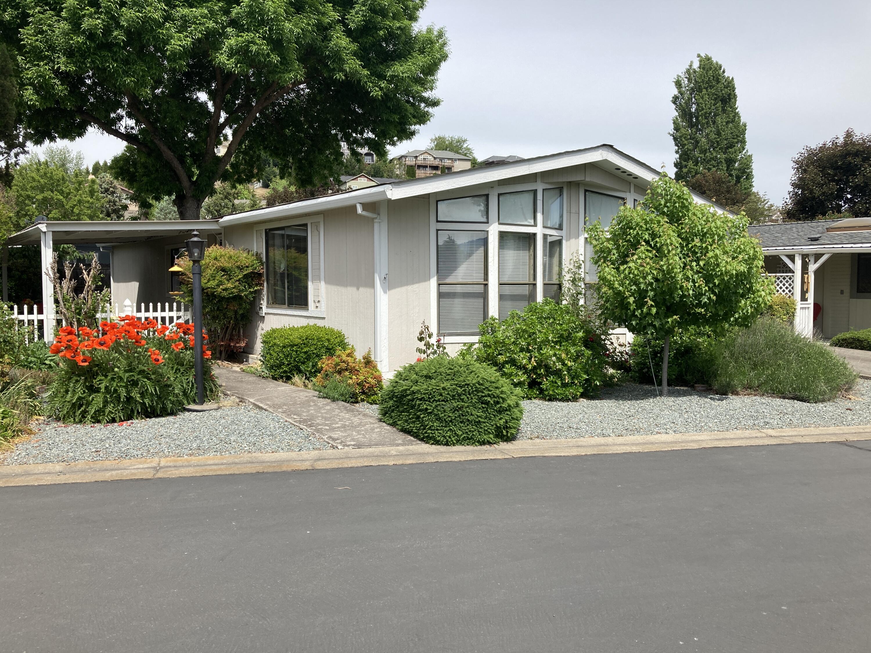 Nicely maintained and landscaped 2 bedroom, 2 bath home in the highly desired 55+ Rogue Valley South Manufactured home park.  Main section of home and bedrooms are all drywall, tape and textured.  Great little breakfast bar, separate dining area with built in hutch and large living room. The laundry area has room for Fridge or Freezer.  All appliances are included. Primary bedroom has en-suite bathroom with deep soaking/garden tub and separate shower enclosure.  Bright and open with lots of natural light, plenty of storage and covered porch-patio area. Yard is fenced and nicely landscaped.  Main shed in carport and second shed in backyard is handy place for all your gardening tools or extra storage. Great location on private lane with fantastic views of pastures and mountains.  Overflow parking nearby.  Boat and RV storage in park, swimming pool, club house and picnic area. Move in Ready.