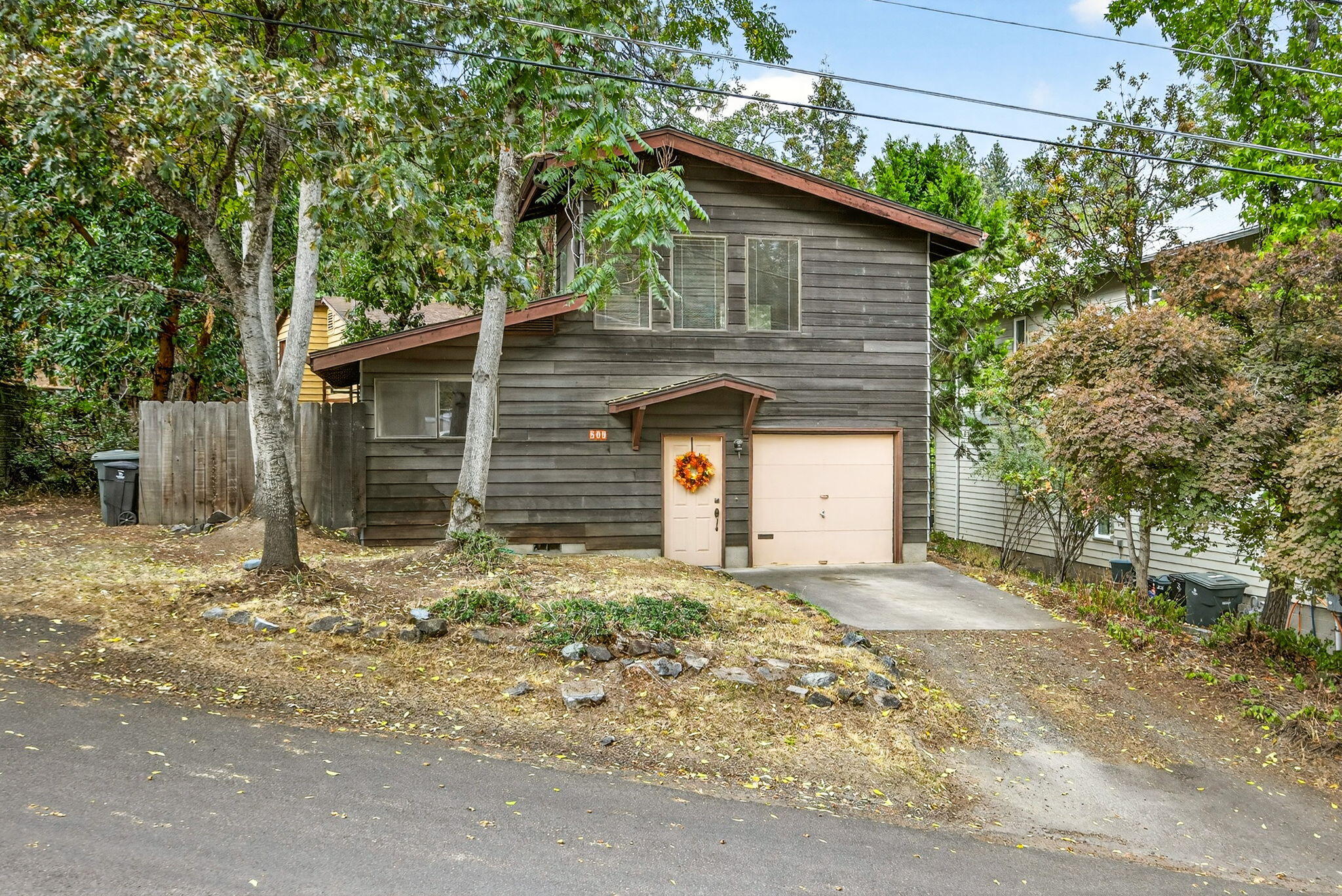 Experience the best of Ashland living in this unique two structure home tucked away on .38 of an acre. Like living in a treehouse, the property provides privacy and natural beauty while being just moments from Southern Oregon University, downtown, shopping, dining and restaurants, Lithia park, and the celebrated Shakespeare Festival. Though the home is in need of some rehab, this rare find offers endless opportunity for creativity—whether you restore its vintage character or reimagine it to suit your lifestyle. A true hidden treasure in the heart of town!