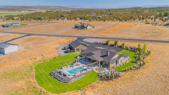 Resort living complete with a stunning seven peaks view and a pool.  Sit back and gaze at the magic of these Central Oregon views while you relax in complete luxury. One level throughout this oasis in the desert includes all the amenities you need with over 5 acres so you can enjoy it on your own terms. Gourmet kitchen with stainless steel Kitchen Aid appliances to entertain or create your own seamless meals. Great room with vaulted ceilings, fan and fireplace. 1575 sq ft shop with RV storage as well.  Room for all of your toys and dreams. 16 minutes to the airport when you need to fly your friends in for that next great experience.