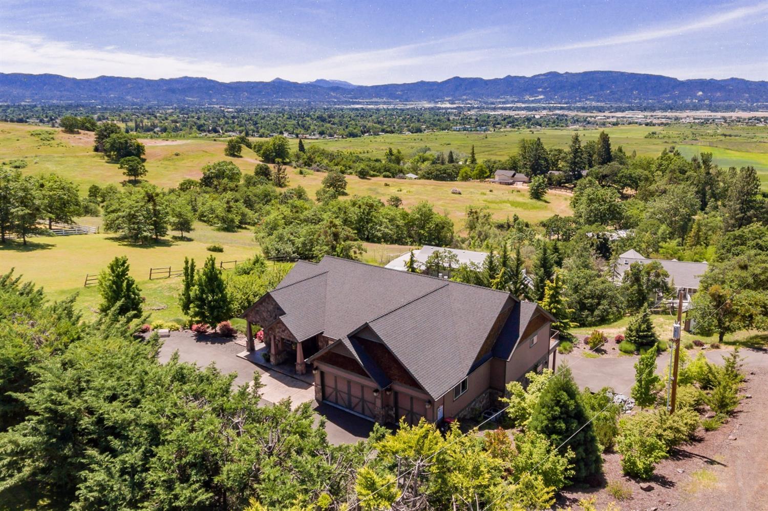 Beautifully crafted custom built home on just over 1 acre with outstanding valley views! Enjoy an East Medford peaceful country atmosphere just minutes to town. Floor plan features two spacious master suites - one on the main level and the other on lower level with private entrance, high vaulted ceilings, large picture windows, three gas fireplaces, formal living room, separate family room, formal and informal dining, office and two laundry rooms plus a bonus room above garage and an additional family room downstairs. Hardwood, stone, and travertine flooring. Kitchen features convection wall oven, built-in microwave, range/oven with 6 burner gas cooktop in island, granite counters and walk-in pantry. Central vac. Security alarm system. Attached 3 car finished garage, RV parking and paved driveway. Nicely landscaped including fenced garden area.