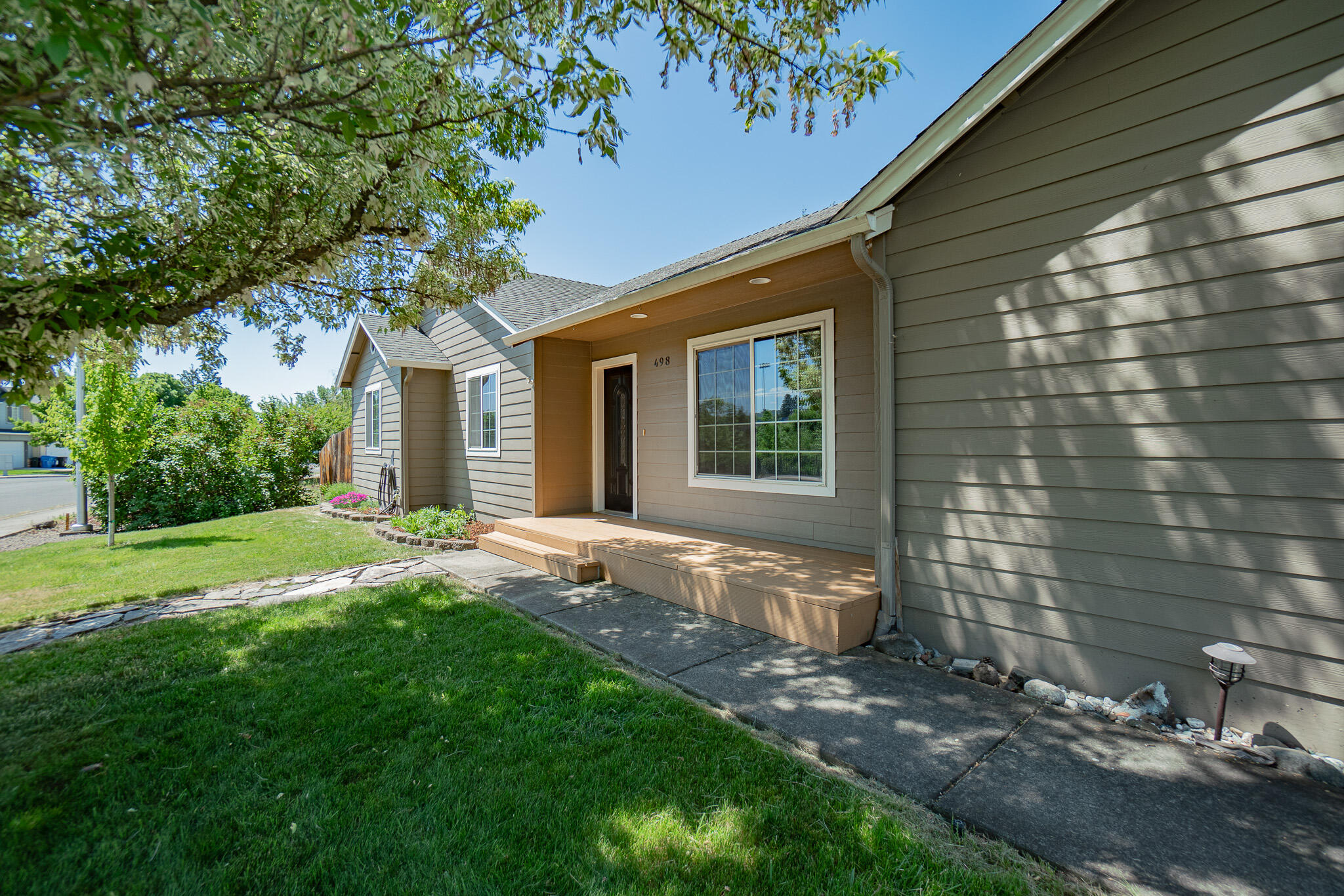 Beautifully laid out on an amazing corner lot overlooking trees and greenery in the front, is this 3-bedroom 2 full bath home! You'll enjoy 1448 Square feet of living on a nice .16 acre lot! The covered front porch invites you to enter into the open light and bright home, great for entertaining with vaulted ceilings, kitchen peninsula and skylights. Warm laminated flooring that runs through the living and bedroom areas. The 3 bedrooms have nice natural lighting, and bathrooms are spacious. Guest bathroom has a spray connection on the toilet that was used for diaper duty (can be a bidet or owner can remove). Don't miss that! Outside is an inviting covered patio space, as well as extended pavers that you could set up a nice bbq on. The backyard lawn lends way to garden boxes on the side yard that could be updated just a little to make your own. The Water heater was replaced in 2022 and the HVAC was new in March of 2020.