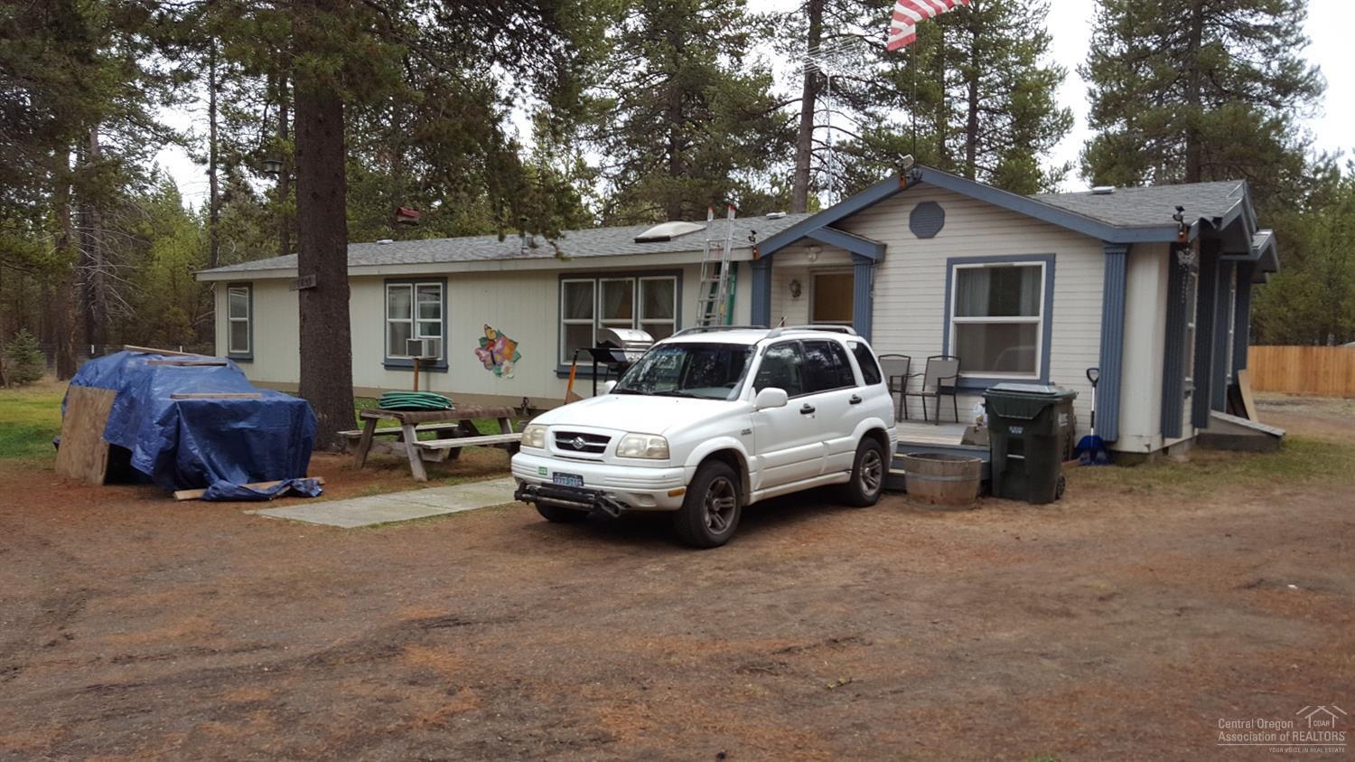 Sought-after location in La Pine. Plenty of room for your toys with full RV hook up. Spacious 1974 square foot, includes Living room and family room as well as service porch that was built at time of set up. Pellet Stove with a nice look and energy efficient. All this on almost one fenced acre. Price reduced, must see.
