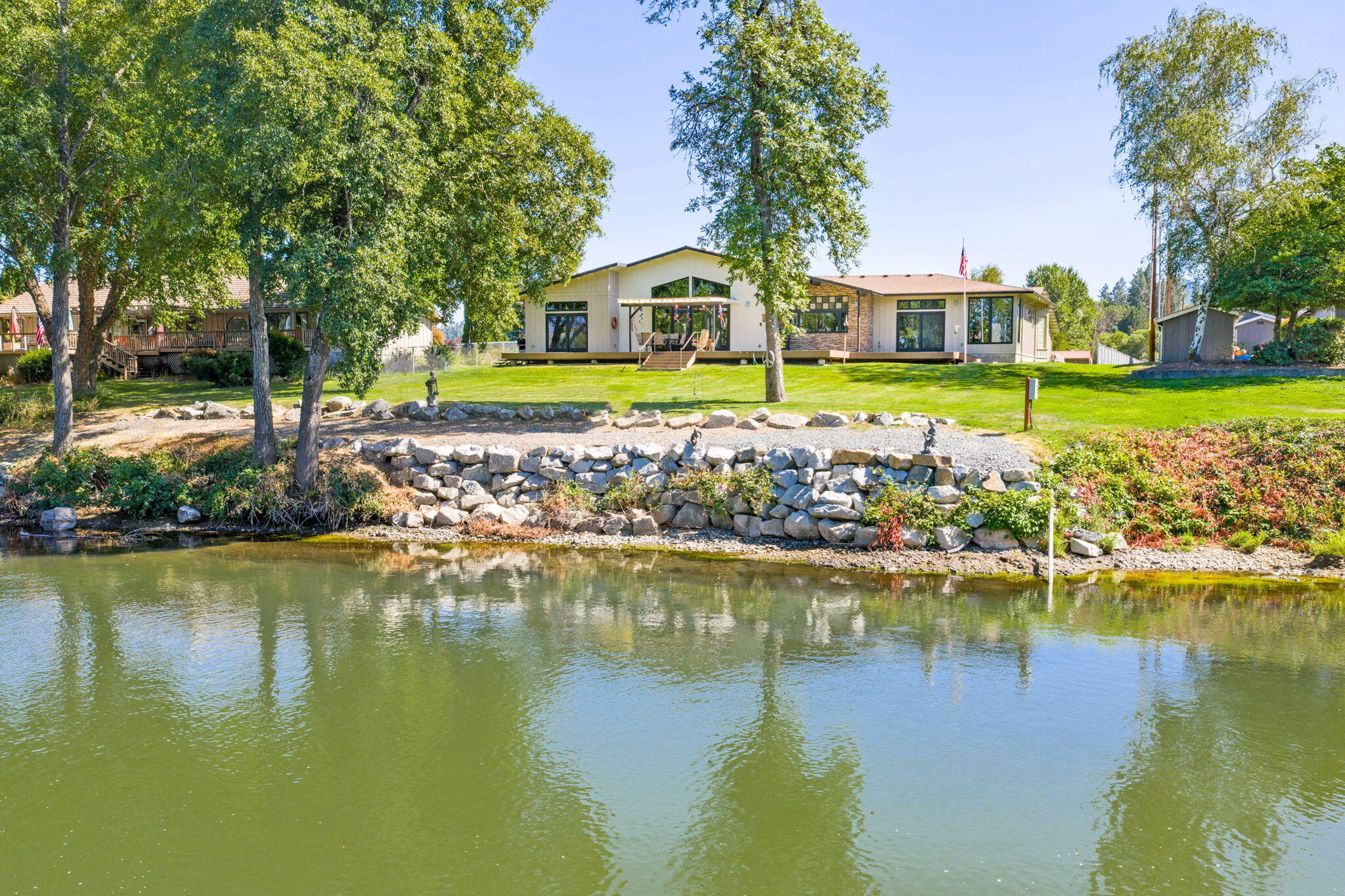 Timeless Northwest Elegance meets Quality Craftsmanship in this custom Gordon Longhurst-built home set on one of the finest stretches of the Rogue River. With sweeping river views from both suites and the main living area, this 4BD/3.5BA home offers refined comfort and exceptional design. The gourmet kitchen features granite counters, double ovens, a 5-burner gas cooktop, walk-in and butler's pantries, and panoramic river-facing windows. Enjoy 10-14' ceilings, solid doors, fine art niches, and Milgard ULTRA Low-E windows. Primary and Jr. Suites are thoughtfully placed in a split plan for privacy. The 4-car garage includes a workshop with 220 and gas heat. Spa-ready patio/courtyard, wine cellar, whole house zoned radiant heated floors, 2 HVAC systems and central vac are just a few wonderful features in this impeccably maintained home. A Video, a separate 360 Tour and a Comprehensive Feature/Good to Know List is available.  Just ask the Listing Agent!