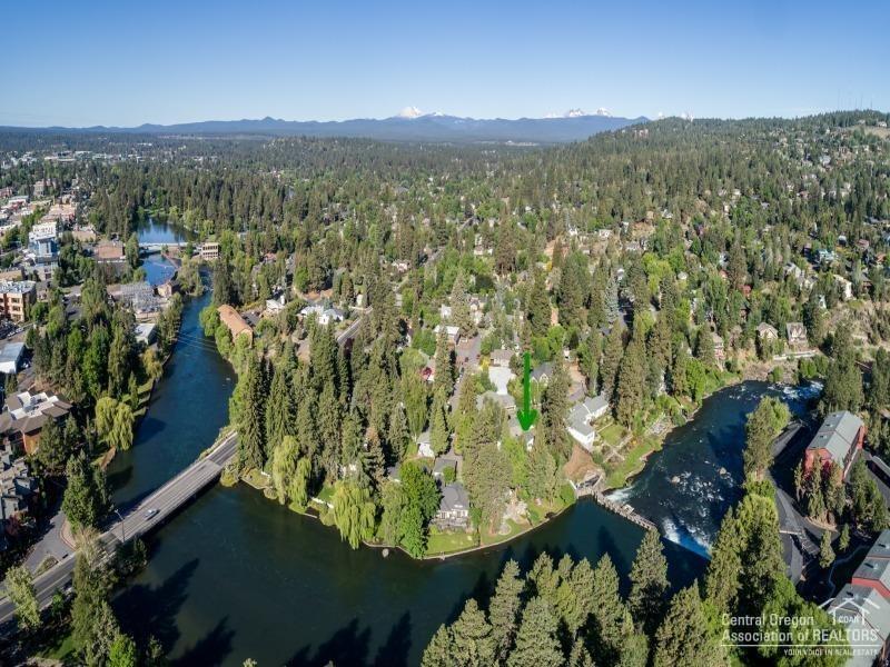 Quintessential Bend cottage with low bank Deschutes river frontage on one of downtown Bend's most coveted streets! Idyllic river views, fantastic deck & a large grassy yard with majestic old growth trees. Outstanding location just a stone's throw from Pioneer Park, the Deschutes river trail, the 1st Street rapids, downtown shops & restaurants. Cottage breezeway leads to a 1B/1b studio with separate entrance also with river views. Huge .31 acre RM zoned downtown lot allows for future building possibilities.