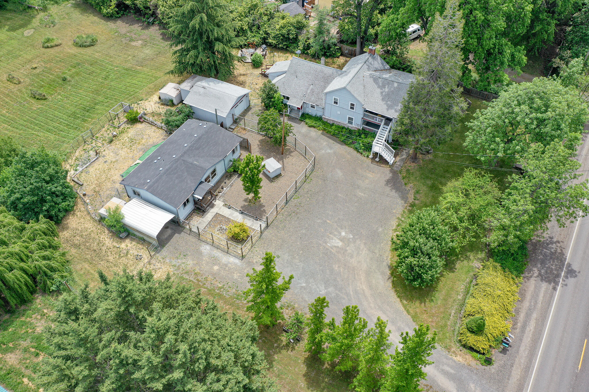 Two homes in the beautiful Wagner Creek Valley with creek frontage. Amazing hard to find property. The large main home was built in 1910 .Plantation style home and features 4 bedrooms and 2 1/2 baths with 2247 square feet as per the county. Large covered porch, rustic woodwork touches throughout the home. Updated kitchen and bathrooms. The second home is a 2003 double wide made by Karsten Homes, with 1188 square feet as per the county. 3 bedrooms and 2 baths. Vaulted ceilings, vinyl planking floors, laundry room, large kitchen and master suite. Large pasture in the rear which goes to the creek. Mature fruit trees and room for a garden. The location can't be beat and is only 5 minutes to town. The two homes allow for an extended family situation or rental income. High speed internet available. The second home has a separate address of 7093 Wagner Creek Road