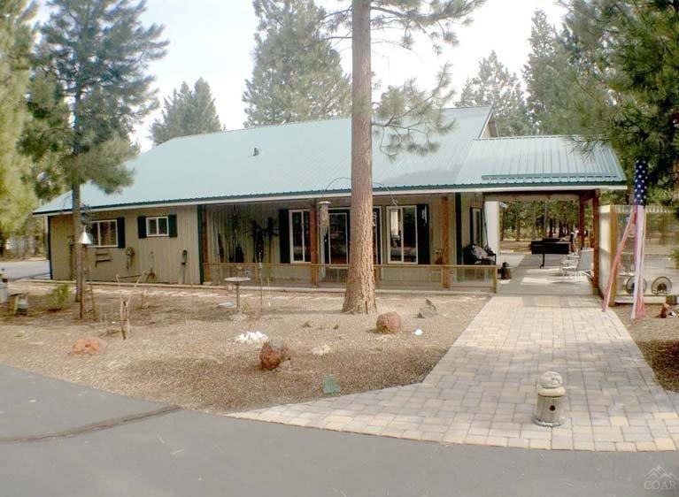 Located in a forest on 1.12 acres, this highly maintained property with a circular driveway was built in 2000. With a 1,008 sq ft, 2 bedroom, 1 bath, single story home with an attached 816 sq ft (48'x17') drive through RV garage with (2) 12 ft roll up doors, shop & woodstove, this private & quiet property is perfect as a full-time residence or 2nd home. Across from the home is the 840 sq ft (28 ft x30 ft) oversized 2 car garage with 220v shop. It's large enough for 2 cars and a boat! Traditional sale.