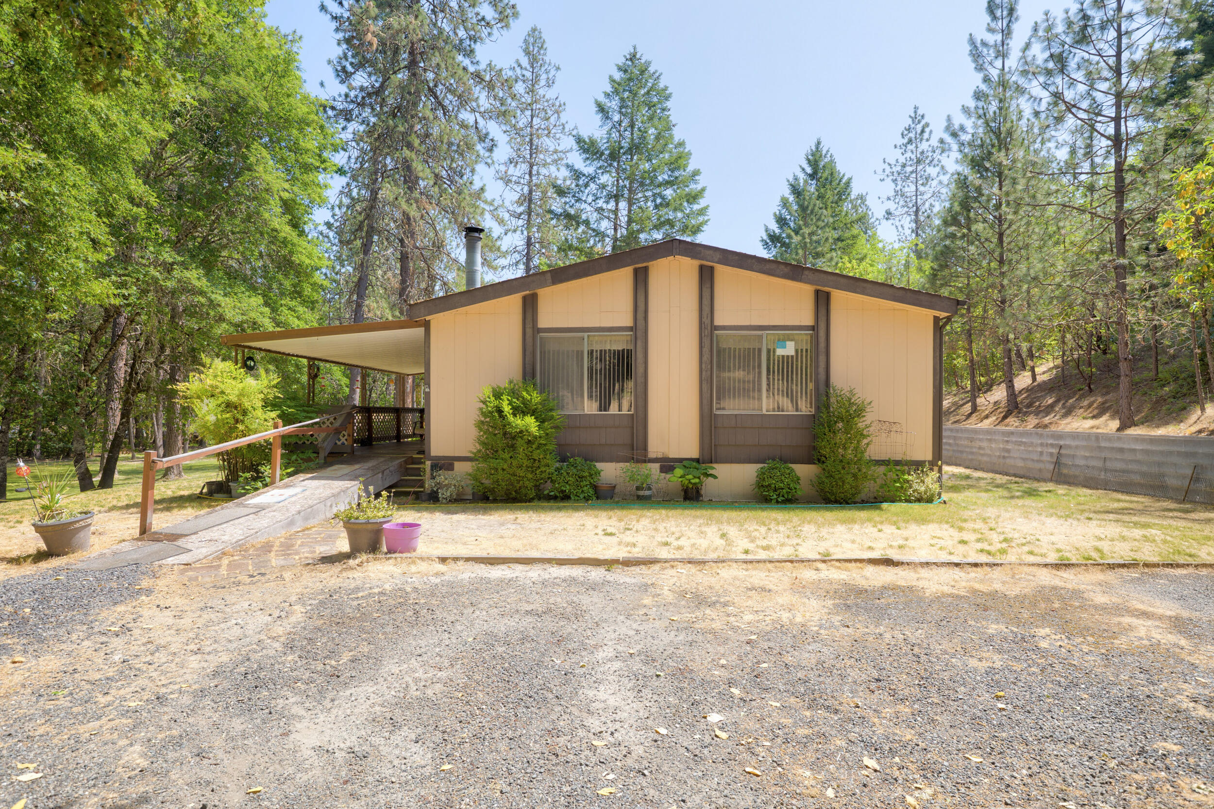 Remarkable opportunity for a first-time buyer or investment with a new roof! This home is nestled on park like 2 acres, serene with almost 1300 sq ft, this 2bd 2 bath is just minutes from the hospital, shopping and town. Open floor plan. Plenty of room to add a shop or barn. The many trees provide ample shade in the summer and the east facing covered porch is the ideal setting for quiet summer tea in the evenings!