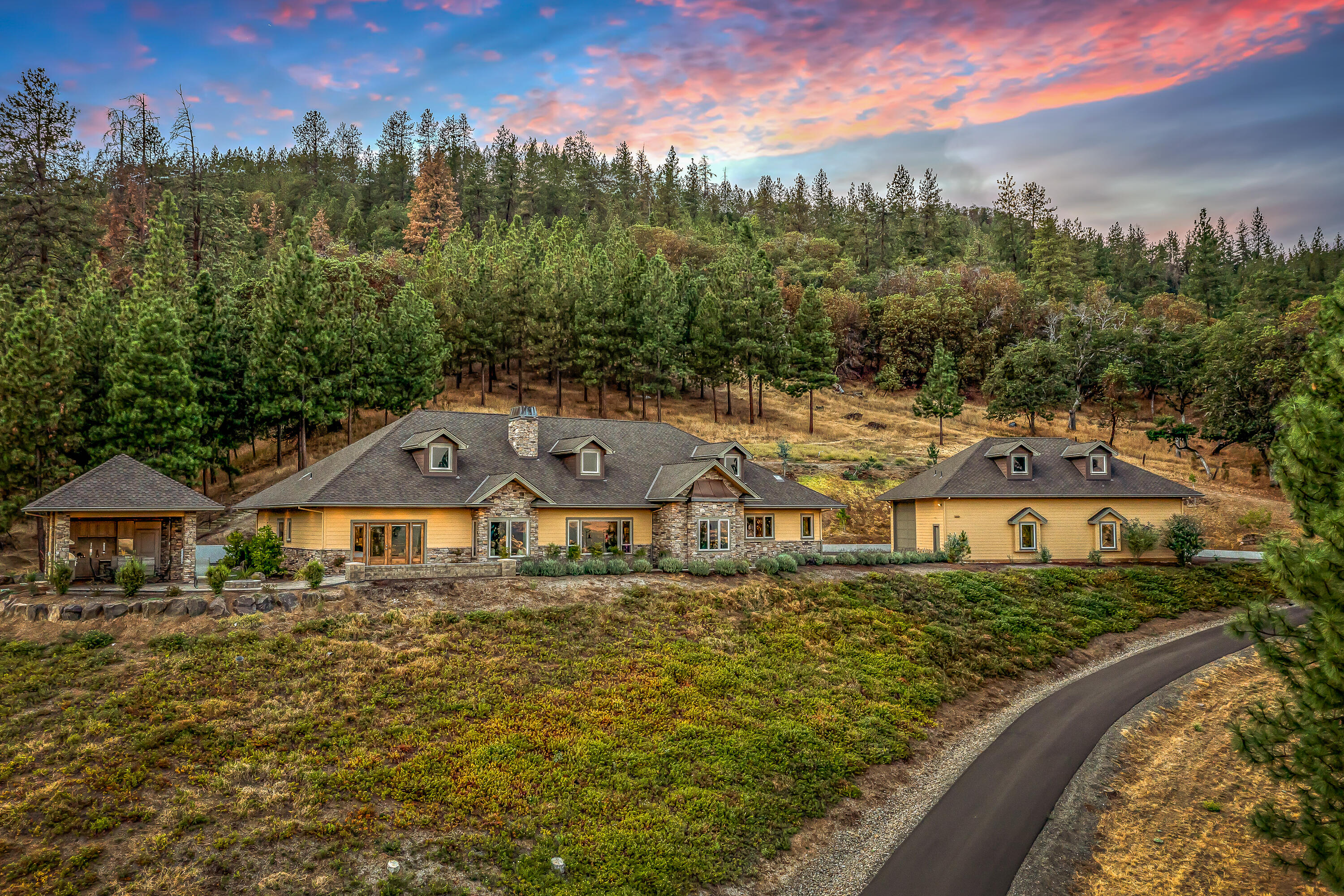 Private single-level country estate on acreage with stunning valley views, detached drive-through RV garage workshop, and amazing outdoor kitchen — just five minutes from historic downtown Jacksonville! Open-concept floor plan with high ceilings, wide-plank hickory floors, gourmet kitchen with pantry, stainless Bosch appliances including convection oven and 5-burner natural gas cooktop, quartzite counters, informal and formal dining areas, great room with gas fireplace, integrated speakers, office with built-in shelving and cabinetry, three full bathrooms with radiant-heated floors, and three bedrooms with exterior French doors including the luxurious primary suite with two separate walk-in closets, jetted step-in tub, and steam shower. Concrete paver patios, firepit, and covered outdoor entertainment area with built-in patio heaters, barbeque, range oven, wine refrigerator, pantry, and dining area. Paved circular driveway through fenced property with two gates. Inquire for details!