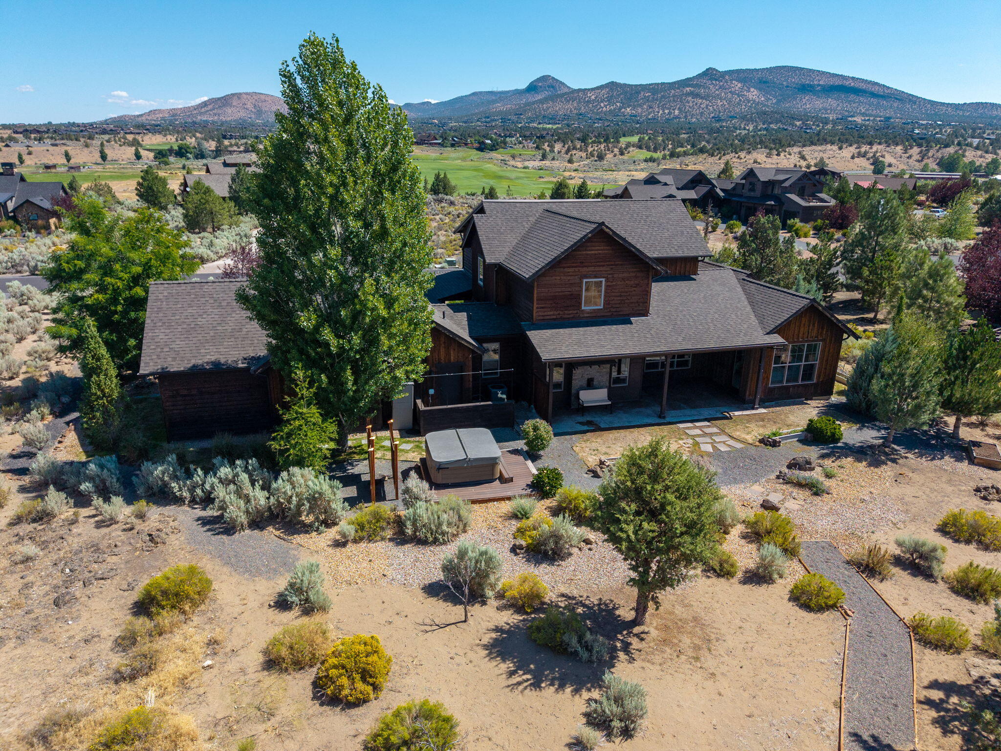 Welcome to your ideal retreat in Brasada Ranch, where rustic charm meets modern comfort. This beautifully crafted ranch-style home with 5 bedrooms backs to expansive common space, offering privacy and wide-open views. Thoughtfully designed with timeless stone accents and rich hardwood flooring, the open-concept great room centers around a stunning floor-to-ceiling stone fireplace with a raised hearth and custom mantel. The spacious country kitchen features a large slab island, stainless steel appliances, tiled counters with coordinating backsplash, and a walk-in pantry—perfect for entertaining or everyday living. The primary suite offers direct patio access, a generous walk-in closet, and a spa-inspired bath. Upstairs, a versatile landing with 3 additional bedrooms, ideal for guests. Enjoy Central Oregon's beauty year-round from the covered back patio. Located within the sought-after Brasada Ranch community, offering access to resort-style amenities, golf, dining, trails, and more!