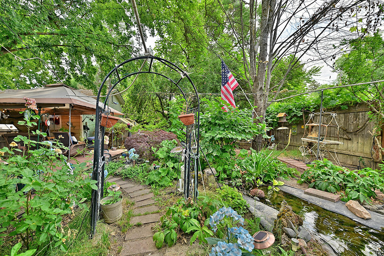 Motivated sellers—considering all reasonable offers! Step into this charming mid-century home featuring original oak flooring, a Bluegrass Living vent-free gas fireplace, ceiling fans throughout, a formal dining room, 3 bedrooms, and a spacious bath. The updated kitchen includes all new appliances: Frigidaire gas range, GE side-by-side refrigerator, GE dishwasher, and a double-basin stainless sink. Enjoy the serene backyard oasis with a red-brick walkway, mature trees, lush landscaping, koi pond, redwood deck, and 6-ft privacy fencing—perfect for entertaining. Property includes a garage plus an oversized separate shop with ample parking. Major upgrades include All new windows (20-yr warranty) & new roof installed Spring 2023. This beautiful home sits on a large lot in a lovely area—don't miss it!