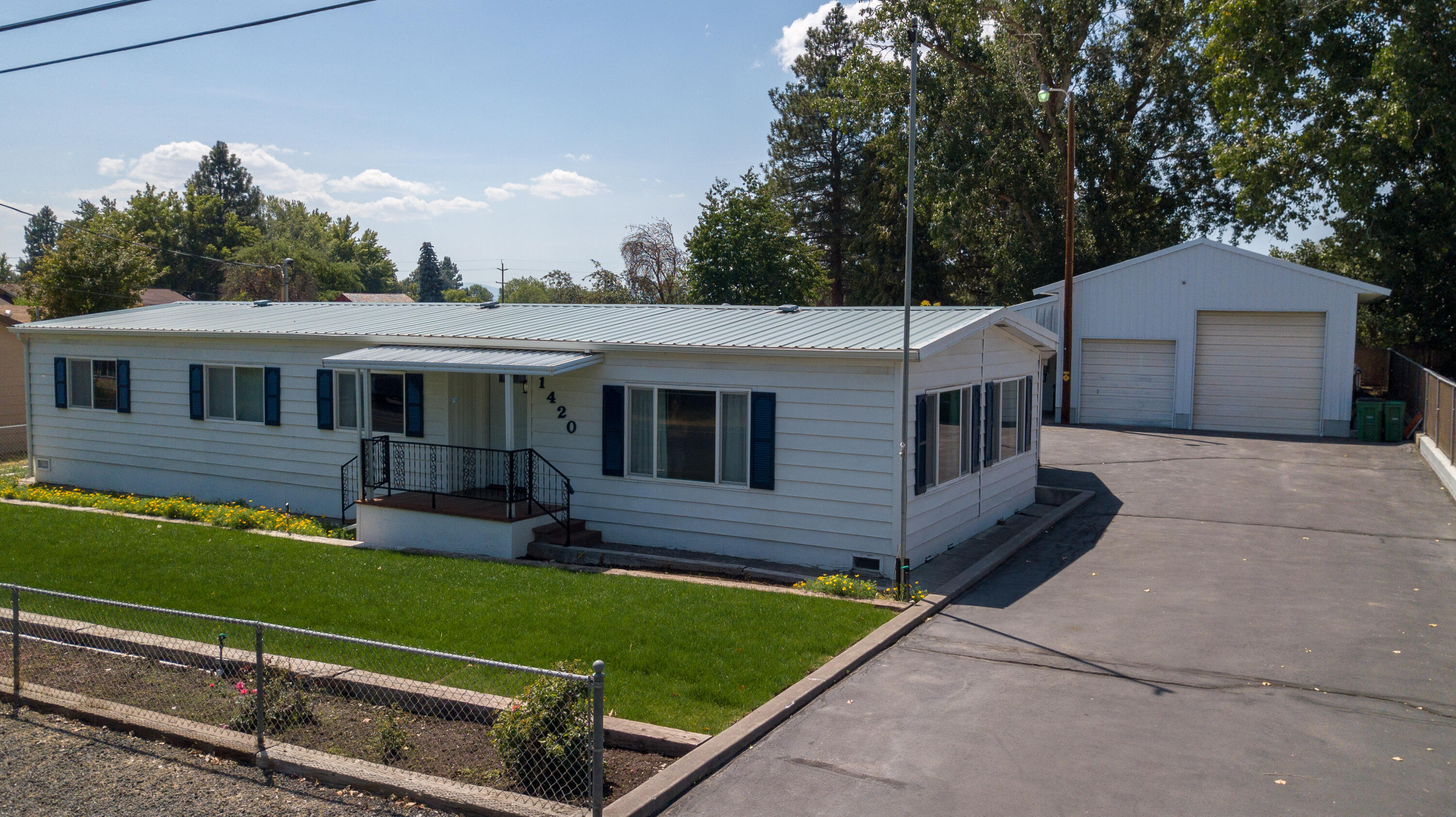 Estate Sale, Motivated seller Very well maintained manufactured home .28 acres. 3 bed, 2 full bath, vinyl windows, new carpet in 2 bedrooms, new vinyl in both bathrooms, laundry room. Heat pump for efficient heating and cooling, electric forced air furnace as additional heat source. Heat pump, furnace, air filtration unit installed 2017. Laundry room has a door to a large sunroom addition. Sunroom is wired to accommodate a hot tub and opens to a spacious covered deck. Peaceful backyard is shaded in the evening and is a perfect spot to watch birds and occasionally deer. New sod in front and back yards,sprinkler system runs off city water. Additional system runs off irrigation water and includes the pump. Yard is fenced and includes a dog run, and an additional storage building. Garage/shop is 48' x 36' with concrete foundation and floors. 8' & 10' garage door, a walk door & double doors into heated shop area. Building is wired for 220 and 2 overhead lifts included.