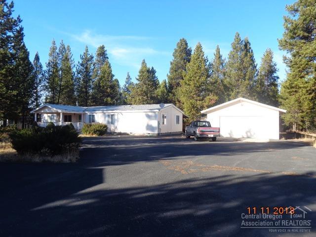 1 acre parcel with a 1782 SF. 3 bed, 2 bath home. Master bedroom and guest bedrooms on opposite sides. Quality kitchen cabinets. Separate Living, Family and Dining rooms. New covered front deck, exterior paint (2018) and partial interior paint (living room and kitchen) all completed in 2018. Metal roof, 2 sheds, animal pen, fire pit and well house, paved driveway, detached double car garage with shop area. Home sets on a block foundation, covered back porch, Partially fenced and gated. Needs some minor TLC. The extensive paved drive way coupled with added care towards landscaping offers a wide range of possibilities for a serene setting. Close to La Pine State Park/Deschutes River and Hwy 97 for commuting. Adjacent lot also available with standard septic installed, power at the lot and partially fenced.
