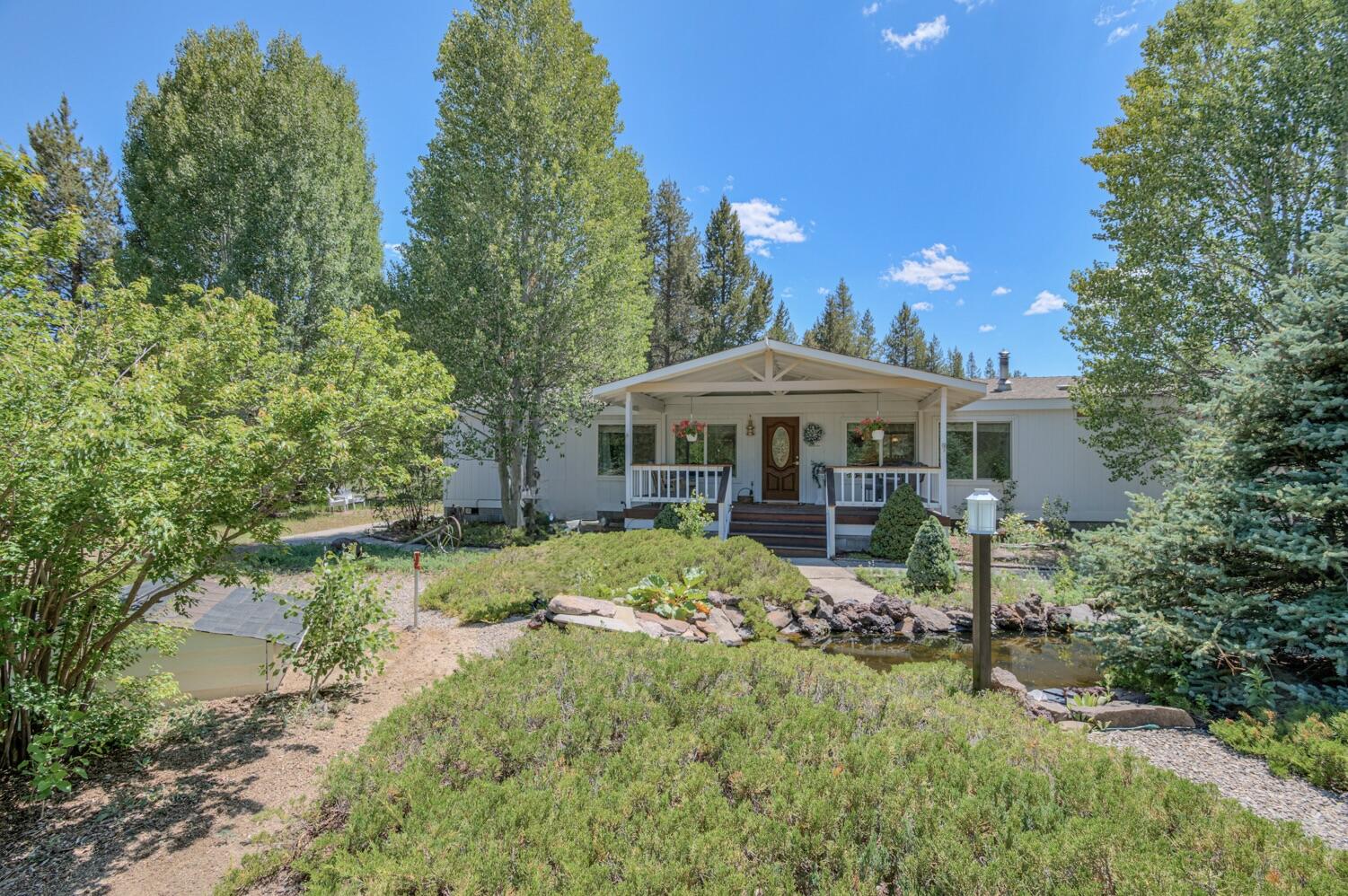 Beautifully updated 3-bed, 2-bath manufactured home on a lushly landscaped 1.07-acre lot just 8 miles from La Pine. This 1,848 sq. ft. home features a bright open floor plan, large windows, and a modern farmhouse kitchen with updated appliances and a walk-in pantry. The spacious primary suite includes a private en-suite bath. Outside, enjoy a large detached garage, a pond with a tranquil water feature, and plenty of room for kids, pets, and outdoor fun. A charming gazebo with a fire-pit is perfect for BBQs and gatherings. Minutes from lakes, rivers, and trails—offering comfort, space, and endless outdoor enjoyment.