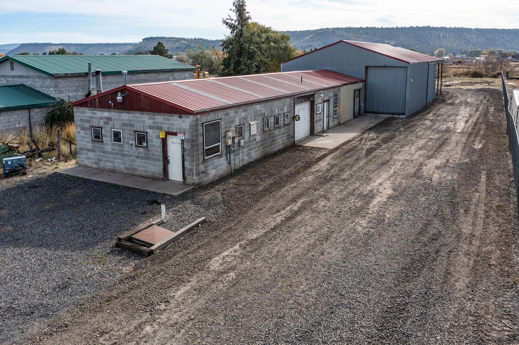 Commercial Building located in Industrial Park on half an acre.  24'x60' block building with an addition of 24'x20' pole building, connected to an additional 40'x60' pole building; all with concrete floor.   40'x22' covered parking behind the shop.  Includes 14'x28' paint booth.  Includes half-bath and office.  Parking in front, side, and back.  Natural gas available.