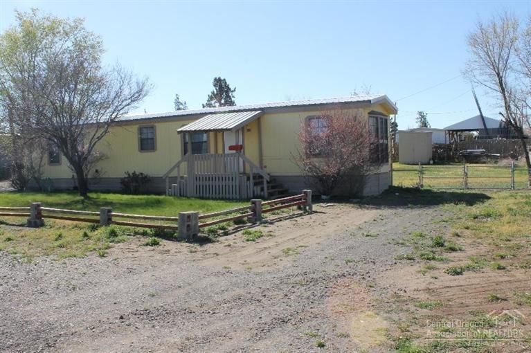 Affordable housing. This home offers a great room floor plan with a bed & bath at opposite ends of the home. Newer vinyl flooring throughout. There is a wheel chair ramp to the back door, large covered parking, room for RV parking plus room for a shop. Lots of potential here. Situated on a large .34 acre lot, 2 storage buildings & fenced back yard too!