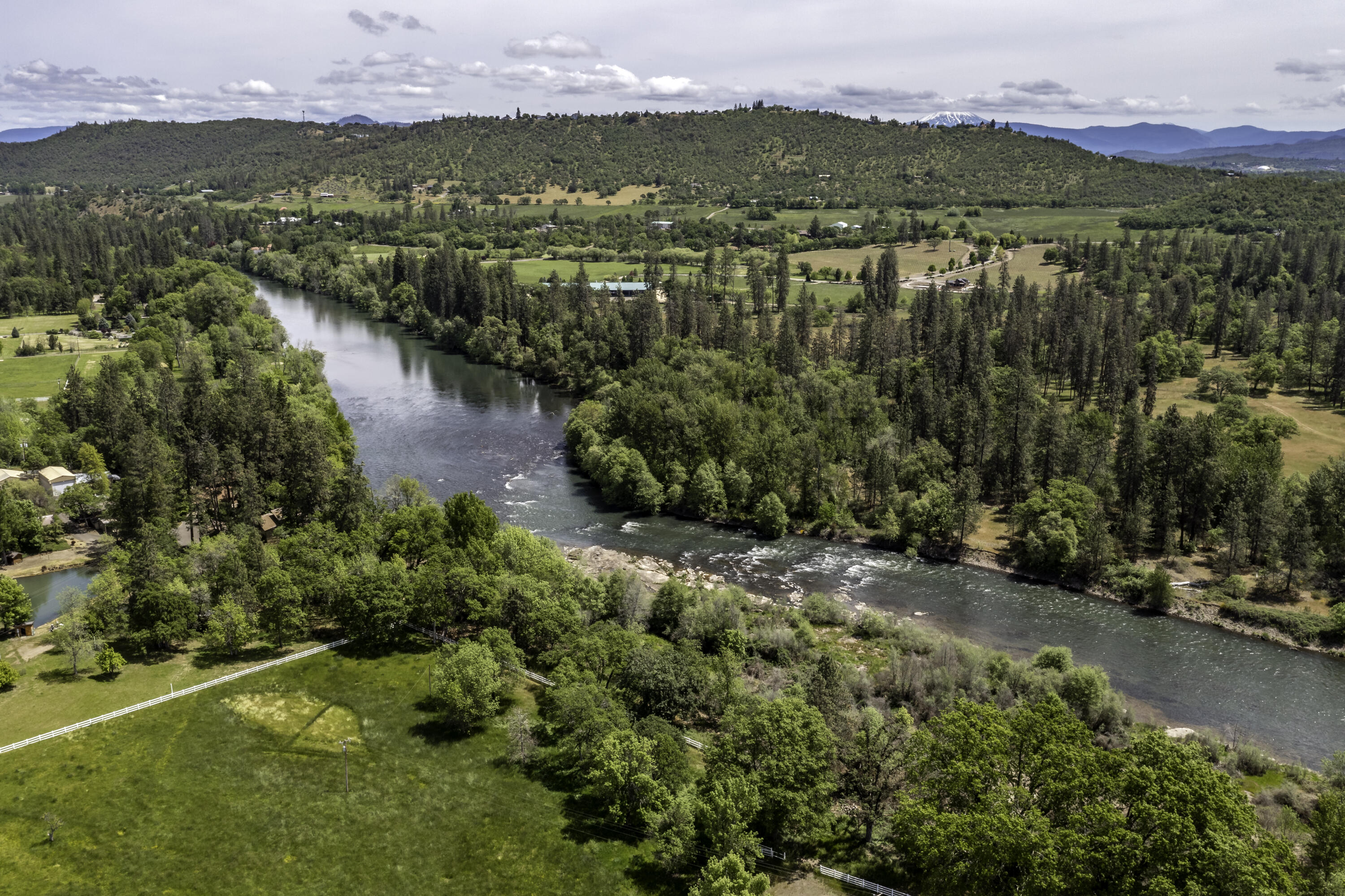 This riverfront property is incredible & versatile! Located on one of the most desirable stretches of the Rogue River with approximately 200 feet of river frontage. The enclosed warehouse/arena is approximately 25,000 sq ft w/ lighting, sprinklers, drainage, steel support systems & heaters. 4 large bays w/ brand new concrete floors throughout, which allows for many uses! Irrigation rights on 20+acres! 600 amps single phase service w/ access to 3 phase power at street. Paved & gated entrance! The main barn features eight stalls & tack room. The secondary barn features 12 stalls & is perfect for animal boarding or storage. 160 ft round pen. 1,000+ sq ft equipment building. 4 pastures that are fenced & cross fenced w/ quality vinyl fencing, totaling 16 acres. The home has been cared for & holds the perfect location to build your dream home! Incredible views of lower Table Rock! This property is located within 15 minutes of the conveniences of Medford, the airport & I-5.