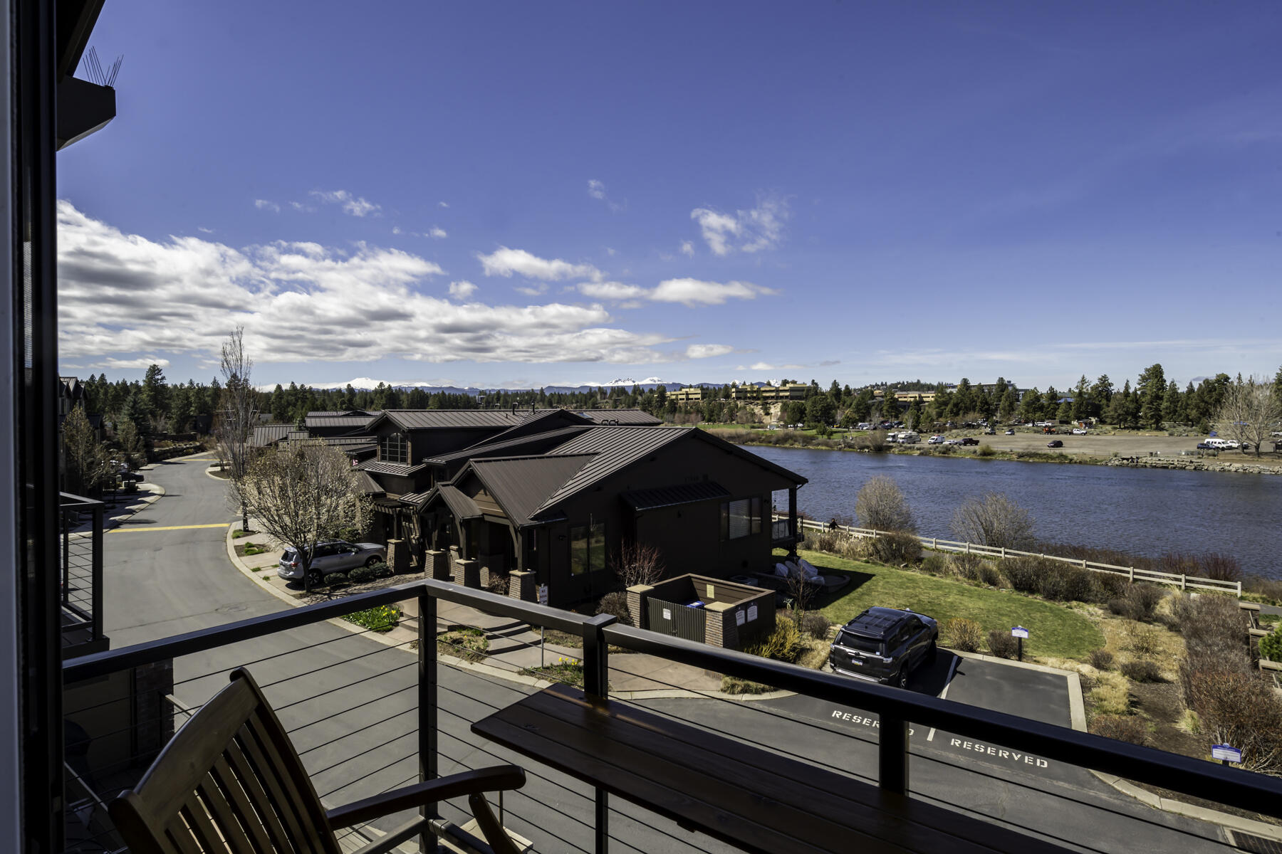 Immerse yourself in The Old Mill District. Take in the unbeatable views of The Cascades and the Deschutes River. Enjoy easy access to trails, paddle boarding/kayaking from your back door. This 3-level townhouse has been meticulously maintained by its original owners and it shows. The main level highlights a guest bedroom/office with private bath, beautiful walnut hardwood flooring throughout, and the kitchen boasts modern flair with designer cabinets, stainless appliance and a 6 burner gas range. There is a dining area off the kitchen and the great room is complete with a gas fireplace. You will love relaxing on the heated main deck listening to summer concerts form the nearby amphitheater. Upstairs, you will find a guest bedroom with private bath,  laundry room and the primary suite with private deck. The 1,100 +/- sq ft garage has room for 3 cars, plus there is a shop area with 2 work benches and full bathroom. This house has it all! Live the Bend lifestyle!