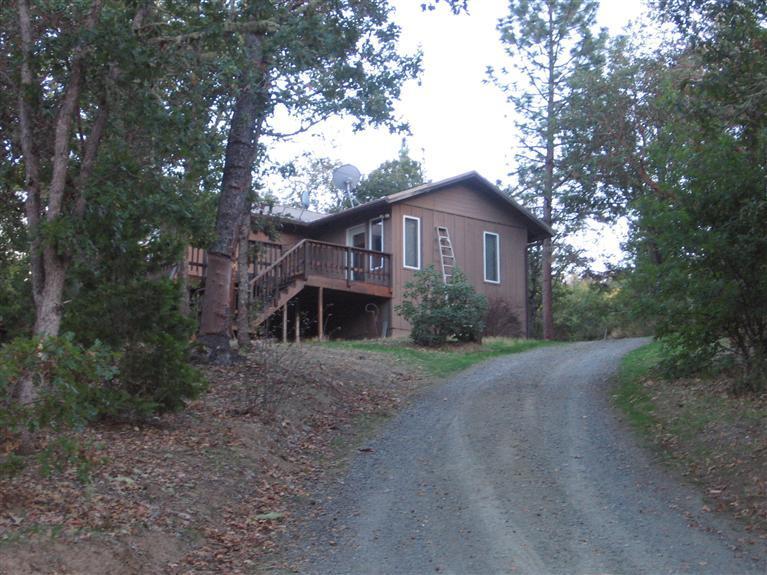 5acres with 2bdrm 1.5bath home & 1bdrm 1 bath studio. Main house was Remodeled in 1993 & features 2bdrm 1.5bath, den/office or possible 3rd bdrm, living room, dining in kitchen, downstairs finished basement features a bedroom, full bath, laundry &space currently utilized as a gym/workout room. There is also additional living space utilizing the 873sqft studio located above the shop/garage which has a living room, Full Bath, Kitchen & separate bedroom. The shop/garage is 528sq ft & shop is wired w/220 great work space for woodworking or metal work. Driveway with Gated access (automatic locking gate accessible by security code). Circular dive around house for ease of maneuverability & carport for extra parking. Great property for someone wanting privacy & rural property with the convenience of being close proximity to town.