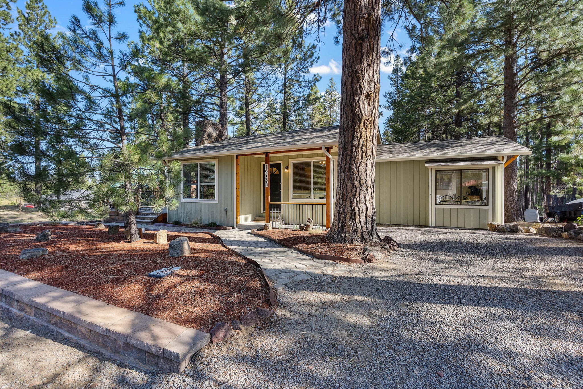 Leave the hustle & bustle of the city behind! Oregon Water Wonderland is a year-round recreational paradise. Community Deschutes River access, boat ramp/dock, w/access to Big River Campground min from the property. This is an opportunity to live & play in the heart of Central Oregon's finest recreation w/world class fly fishing, hiking, Mt Bachelor winter/summer fun & the high lakes! Home sits on a half-acre w/well maintained gravel drive, covered entry, wood panel adorned vaulted ceiling in main living w/cozy wood burning FP & sliders to the massive wrap around porch. Laminate flooring in main + an abundance of natural lighting throughout. Open kitchen w/new flooring, plenty of cabinetry for storage/counter prep space & eating area w/window seat. Vaulted primary on main w/private deck access, dual sinks & tile surround shower/tub combo. Addtnl bedroom w/full bath in the massive daylight basement, detached garage + covered parking spot, tons of room for all your toys, RV, & critters!