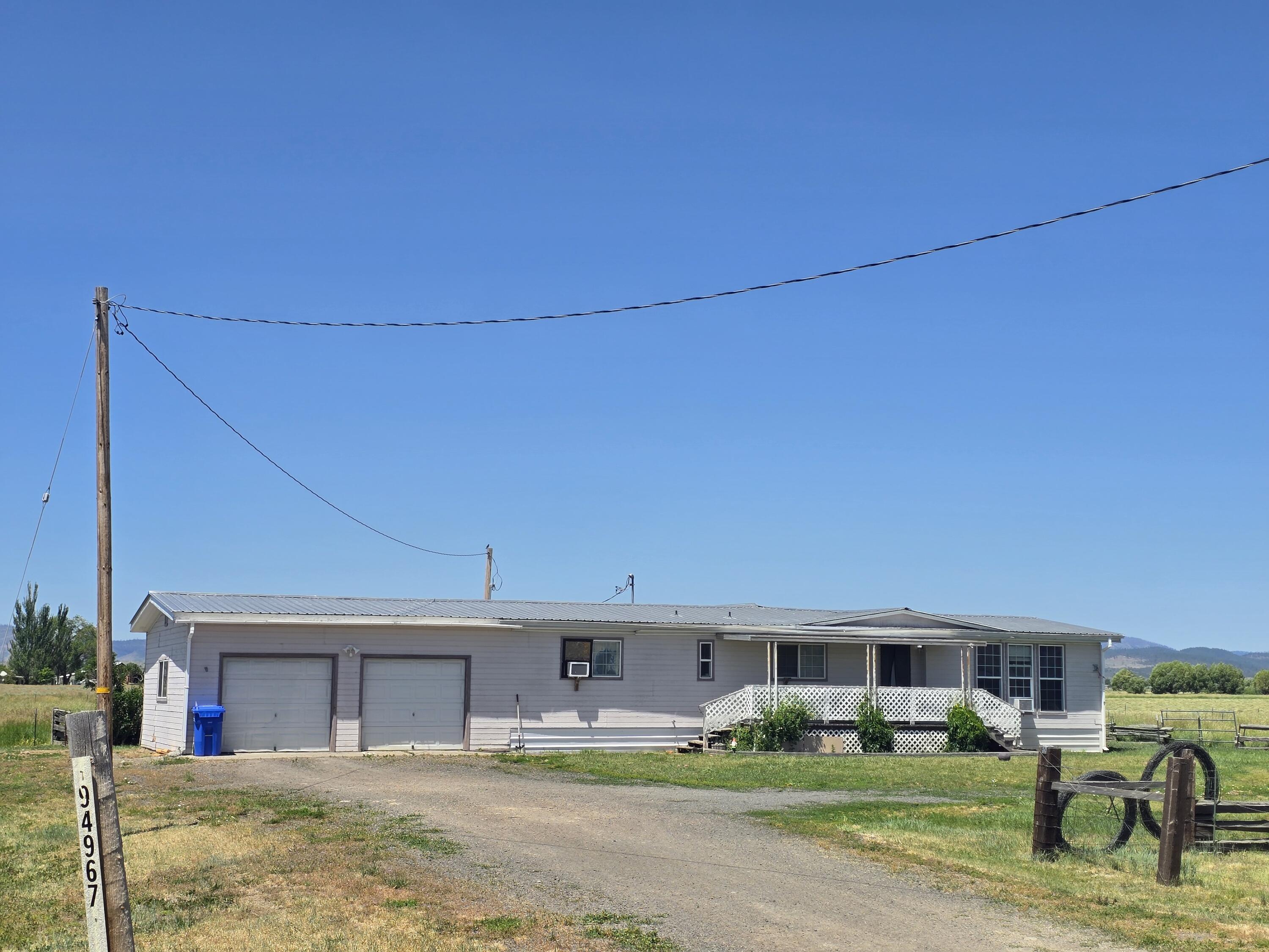 This 3-bedroom, 2-bath home offers wide-open living just minutes from Lakeview, with sweeping views of the Warner Mountains and productive pasture ground all around. With easy year-round access off Hwy 140, it's an ideal setup for those looking to get out of town and into clean country air. The home features a durable metal roof, an attached two-car garage, and a shaded front porch. The backyard features a fenced lawn, a fire pit, and ample space to relax or entertain. Inside, you'll find a functional layout with a central living area, practical kitchen, and laundry/mudroom entry. The property is served by a well, septic, and overhead power. Out back, there's ample open ground and a small livestock shelter-perfect for 4-H and FFA projects, backyard poultry, or hobby-scale gardens. Plenty of space to build out your vision without starting from scratch. Whether you're a first-time buyer, young family, or someone looking to reconnect with rural life.