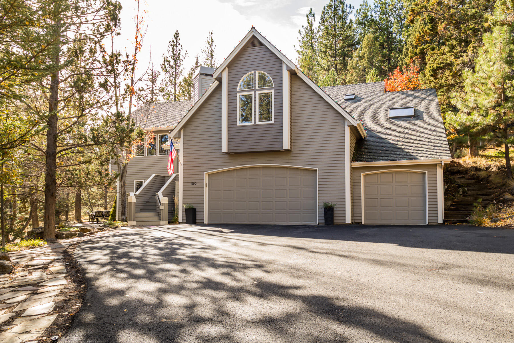 Nestled beneath ponderosas on a private acre lot in the heart of Bend's Westside, this City View home has been beautifully remodeled with meticulous attention to detail. In the great room, vaulted ceilings complement a fireplace with rift white oak built-ins, custom millwork, and an artisan steel surround. The kitchen has been completely reimagined with elegant honed Jet Mist granite counters, a spacious center island topped with honed Carrara marble, custom cabinetry, and new gourmet SKS appliances and custom range hood. An adjacent dining area opens to an expansive back deck and flagstone patio with firepit area. New wide-plank European oak wood flooring flows throughout the main level and downstairs, where a generous recreation space features a custom walnut, iron, and glass bar with beverage fridge, accent lighting, and access to a separate outdoor patio. Additional features include a new HVAC with humidifier, 3-car garage, EV charger, and private community tennis courts.