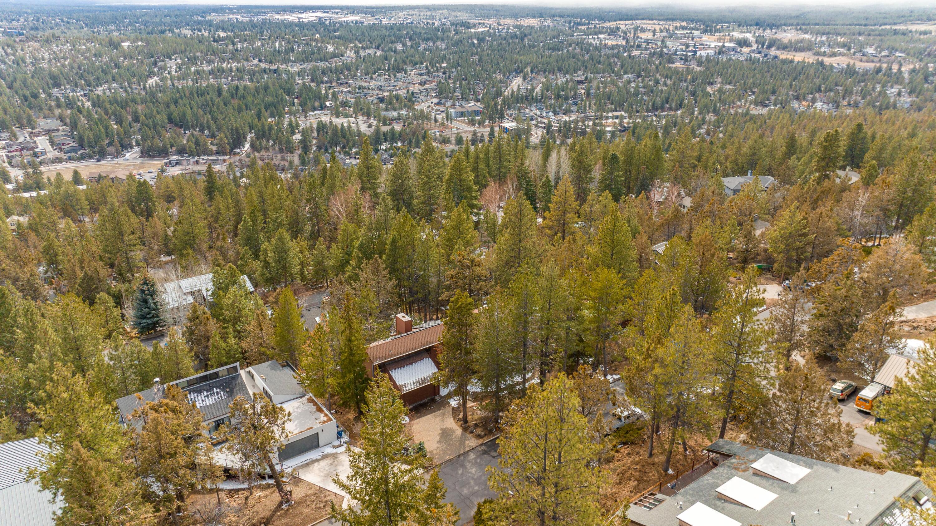 Welcome to an updated luxury mountain retreat on a half-acre in the desirable West Hills of Bend! This home features an open floor plan with high ceilings, exposed beams, large windows, a big fireplace & expansive living areas. The kitchen is a chef's dream with a view of Mt. Bachelor, a oversized island, quartz counter tops, a large stainless-steel sink, high-end appliances & overflowing storage. Relish the privacy of the primary bedroom, across the hall from the other bedrooms. Plush with a private deck to take in views of the Southwest, a remodeled bathroom with a soaking tub, tiled walk-in shower & dual sinks with quartz counter tops. Surrounded by the trees in the yard, the entertainment is endless. Enjoy the beautiful low maintenance landscape with gorgeous views whether you are dining on the deck, lounging on the patio, playing on the sports court or soaking in the salt water hot tub. Perks of extra lodging in the 1 bedroom, 1 bath studio.