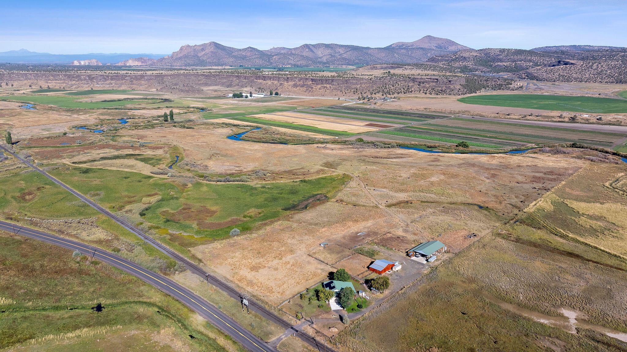 95 acres with nearly a mile of Crooked River frontage and 42.5 acres of irrigation. Updated 3-bedroom, 3-bath home offers modern comfort and sweeping Cascade Mountain and Crooked River Valley views. Improvements include a large hay barn, 2-stall barn/shop with turnouts, and mostly fenced pastures with cross-fencing, ideal for cattle, horses, or hay production. Excellent bird habitat, duck hunting, and fishing make this property a true recreational retreat. Wildlife and outdoor adventure begin right out your back door. Conveniently located near Redmond and Prineville, this property blends productivity, recreation, and natural beauty in one exceptional package. Perfect for those seeking a working ranch, hobby farm, or private getaway in Central Oregon.