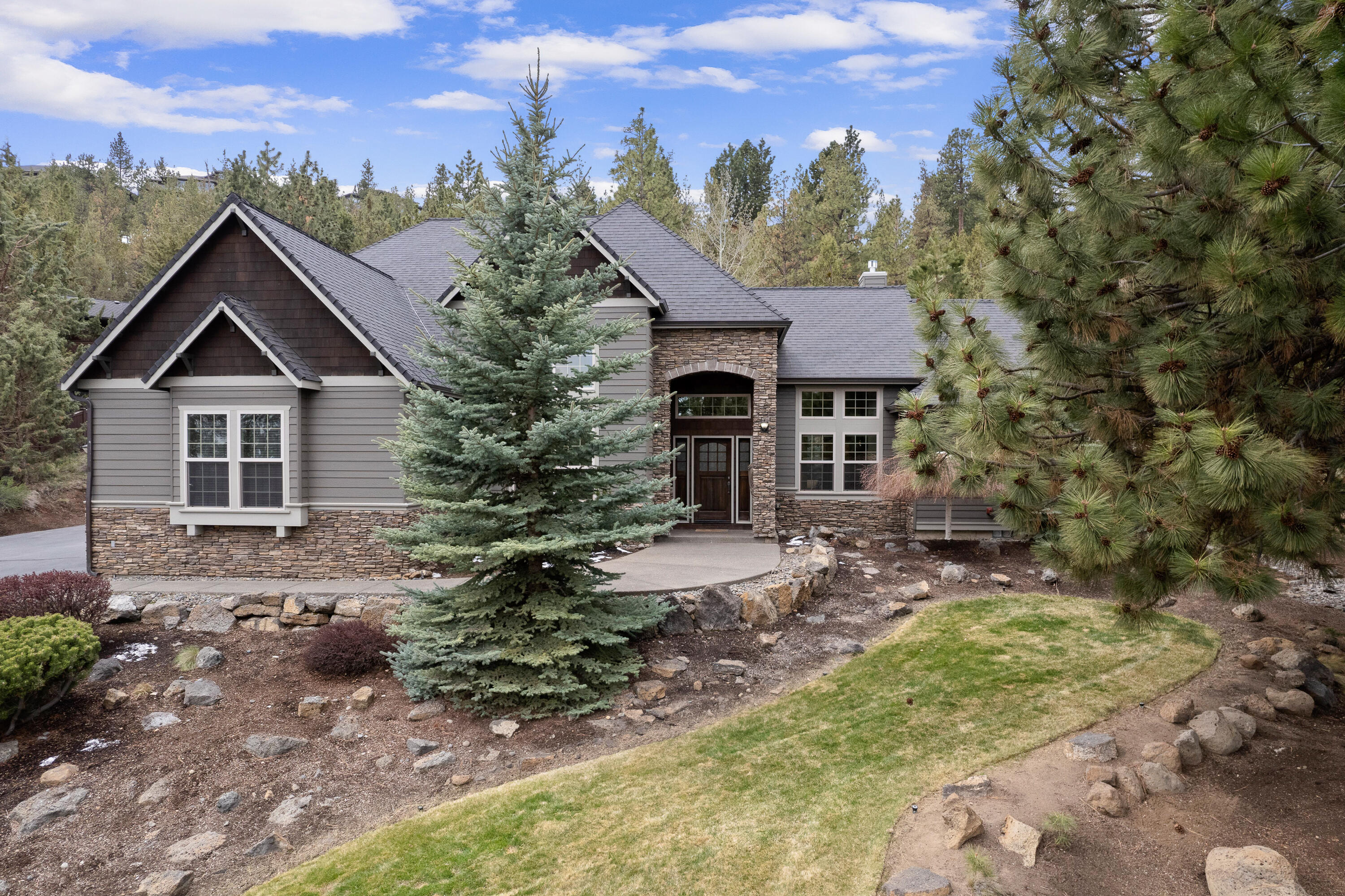 Amazing Awbrey Butte home on nearly 1 acre! This Northwest style home opens to a dramatic living room with 20' ceilings, gorgeous cabinetry, and a floor to ceiling fireplace and hearth. Spacious cook's kitchen with granite, JennAir appliances, plenty of storage, and a generous working island which also functions as a bar for informal dining. Main level Primary Suite features 13' vaulted ceilings and more fabulous space, including a reading nook. Primary bath has dual vanities , jetted tub and his and her walk-in closets. 3 additional en suite bedrooms offer excellent separation from Primary and easy access to the loft and bonus room. This entire home is wired for sound, including the expansive back paver patio. The beautiful landscaping creates a very private space for entertaining. 3 car garage and extra storage for all your Bend gear. Enjoy the proximity to Westside schools, amenities and trail systems.