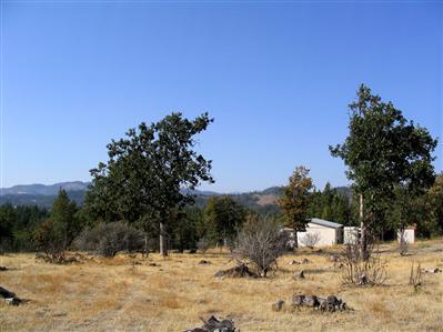 Spectacular views from this 2 1/2 acre level parcel. Peaceful country setting between Eagle Point and Butte Falls. 1981 built mobile home is livable but value is in the land. Detached garage/shops, barn, and outbuildings.