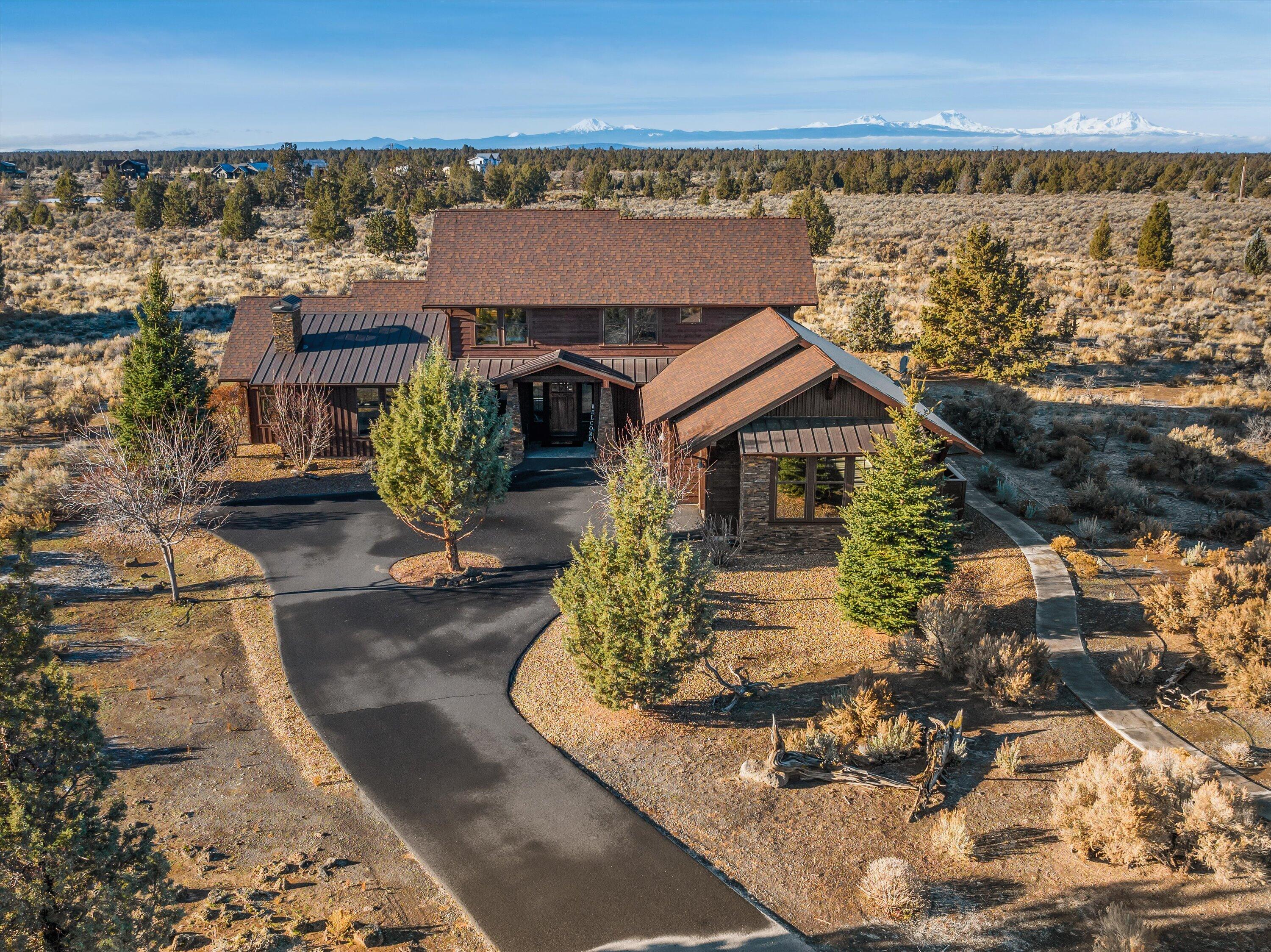 Gorgeous two-level NW style home accentuated w/ stone accents & stained wood siding on the exterior. This home abuts BLM w/ Cascade Mountain views & will take your outdoor living experience to another level. There is a large back patio, dining area, & fire pit to enjoy the outstanding sunsets. An ideal home for the entertainer w/ a cozy great room that leads into the beautiful kitchen & dining room. The kitchen features stainless steel appliances & walk-in pantry. Slab countertops & island are perfect for the home chef. Beautiful hardwood flooring throughout the majority of the main level, a stone fireplace surrounded by built-ins in the great room. The primary bedroom is a peaceful oasis w/ a large walk-in closet, soaking tub & private outdoor access. A den/office space on the main level that could be additional bedroom offers a versatile option. The upper level features a rec room w/ built in bunk beds. Two additional bedrooms, full bathroom, & three car garage complete this home.