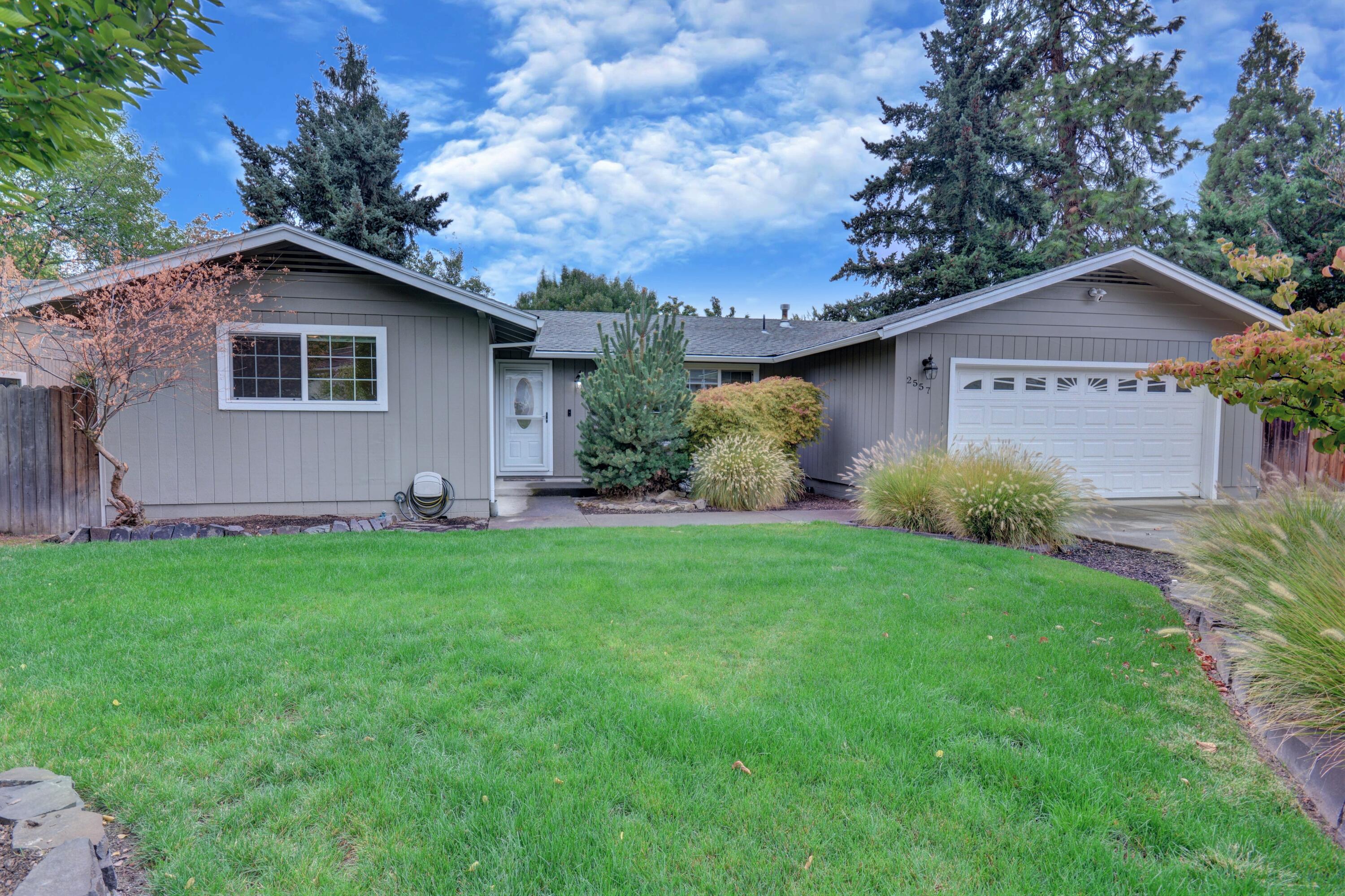 This wonderfully renovated, and meticulously maintained East Medford home is sure to impress. The whole house just feels comfortable! From the entrance into the formal living room with lots of natural light, to the three spacious bedrooms, and the additional large family room, separated by the kitchen and dining area. The kitchen is ready for the chef in your family with a new gas range and modern appliances along with custom cabinetry and granite countertops framed around a classic farmhouse sink.  Both bathrooms have been completely renovated from top to bottom, featuring modern fixtures, cabinets, and flooring, with a stand-up shower in the main bathroom and a soaking tub in the guest. The nicely landscaped front yard shows great curb appeal as well as maximizing the private feel of the home. Relax on the deck overlooking the very private, fully fenced backyard, complete with a new Hot Springs Spa, accessible from the main bedroom and the family room. 1 year Home Warranty Included.