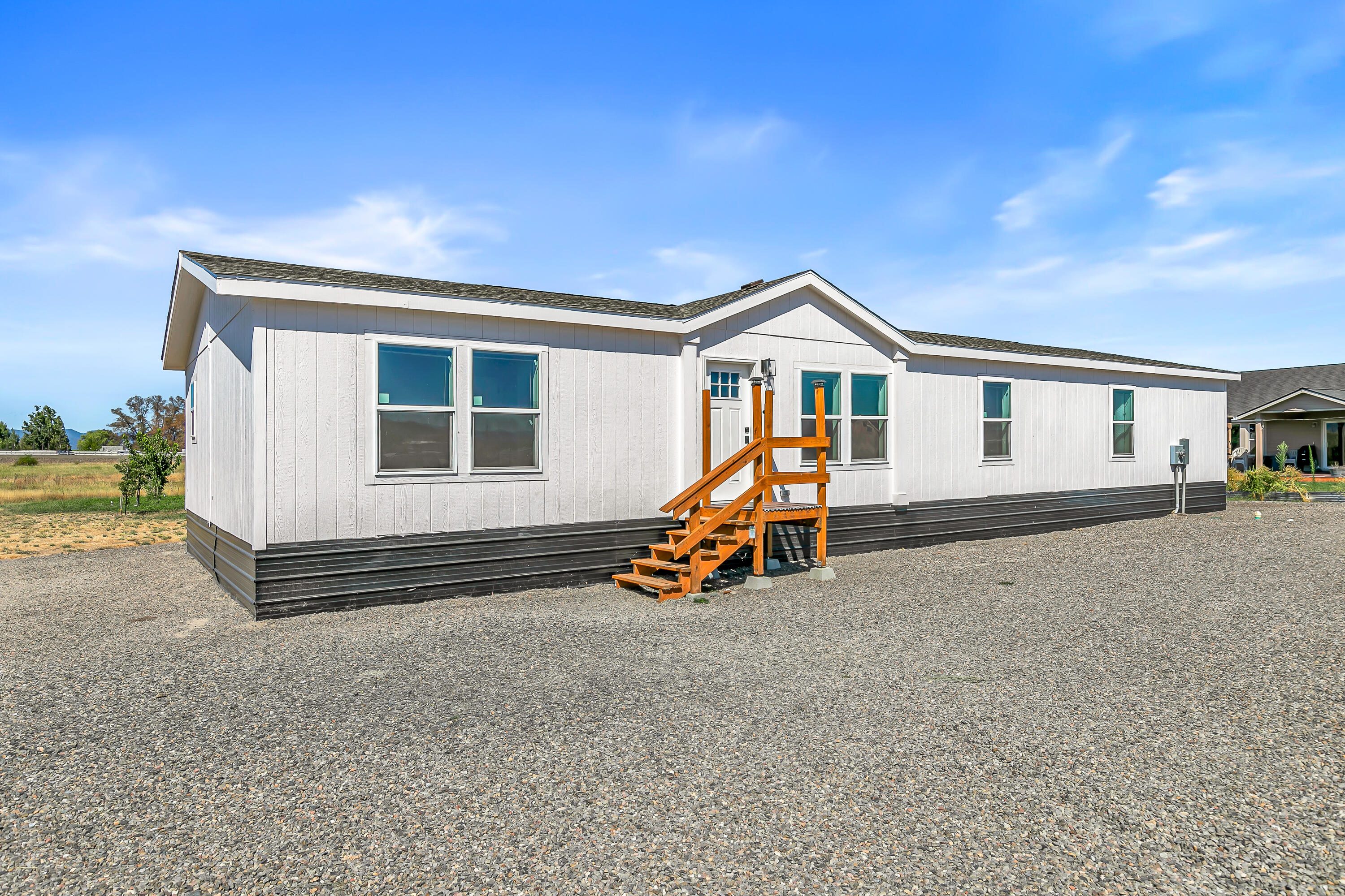 This beautiful Energy Star-rated manufactured home is in search of a new homesite, offering you the freedom to place it on the property of your choice. Whether you're planning a multi-family living arrangement or looking to add rental income to your land, this home is an ideal solution for flexibility and comfort.  Inside, you'll find a thoughtfully designed 4-bedroom, 2-bath layout with two separate living spaces—perfect for accommodating family or guests. Each bedroom includes a spacious walk-in closet, providing abundant storage throughout.  The centerpiece of the home is the modern kitchen, featuring a large island, sleek stainless-steel appliances, and generous counter space that makes cooking and entertaining effortless. With its open-concept design and energy-efficient construction, this home blends contemporary living with sustainable value.
