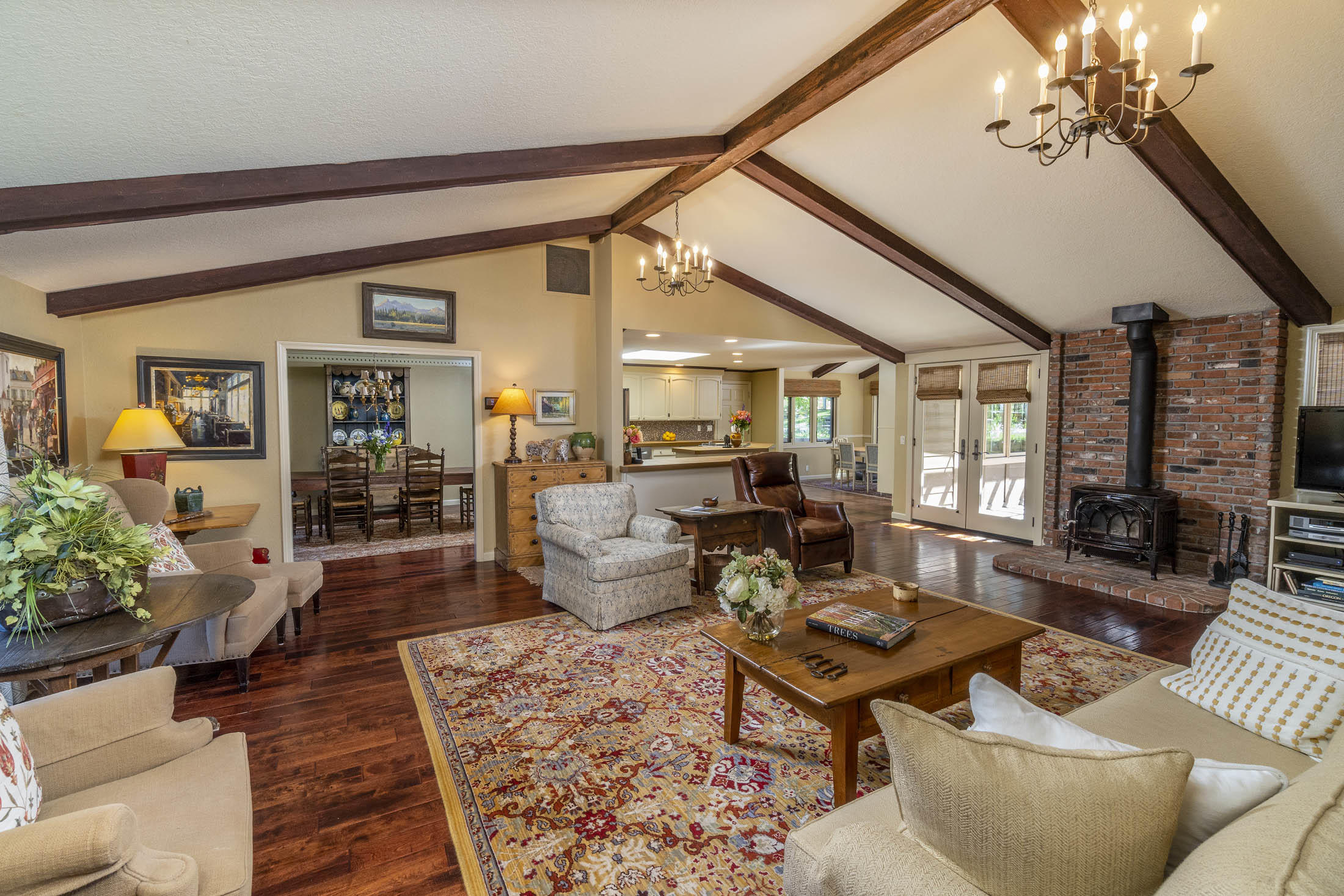 Step into luxury in this beautiful home  surrounded by the privacy of 2.71 treed acres in the desirable Woodside Ranch neighborhood. This custom home offers 3474 sqft of living space on a single level. The foyer opens to a beautiful entertaining space w/vaulted ceilings, lots of light, wood burning stove. In the kitchen, enjoy Bosch SS appliances, Jenn-Aire cooktop/oven & custom cabinets. Dining area overlooks the back yard w/access to patio deck. Primary suite offers an open vaulted room to enjoy the sitting area with French Doors leading to patio deck, perfect for your hot tub! The 2nd primary suite is bright & light w/access to side deck. Attached Apartment w/LR, Kitchen, Bedroom, Bath w/private entry is a BONUS! Beautiful landscaped yard w/water feature, front/back sprinkler system, paver walk ways, retainer walls & gated RV parking, raised garden beds & much more. Fenced & 2 automatic gates for security. See Home Improvement List for more info. Come see & enjoy the BEST of BEND!