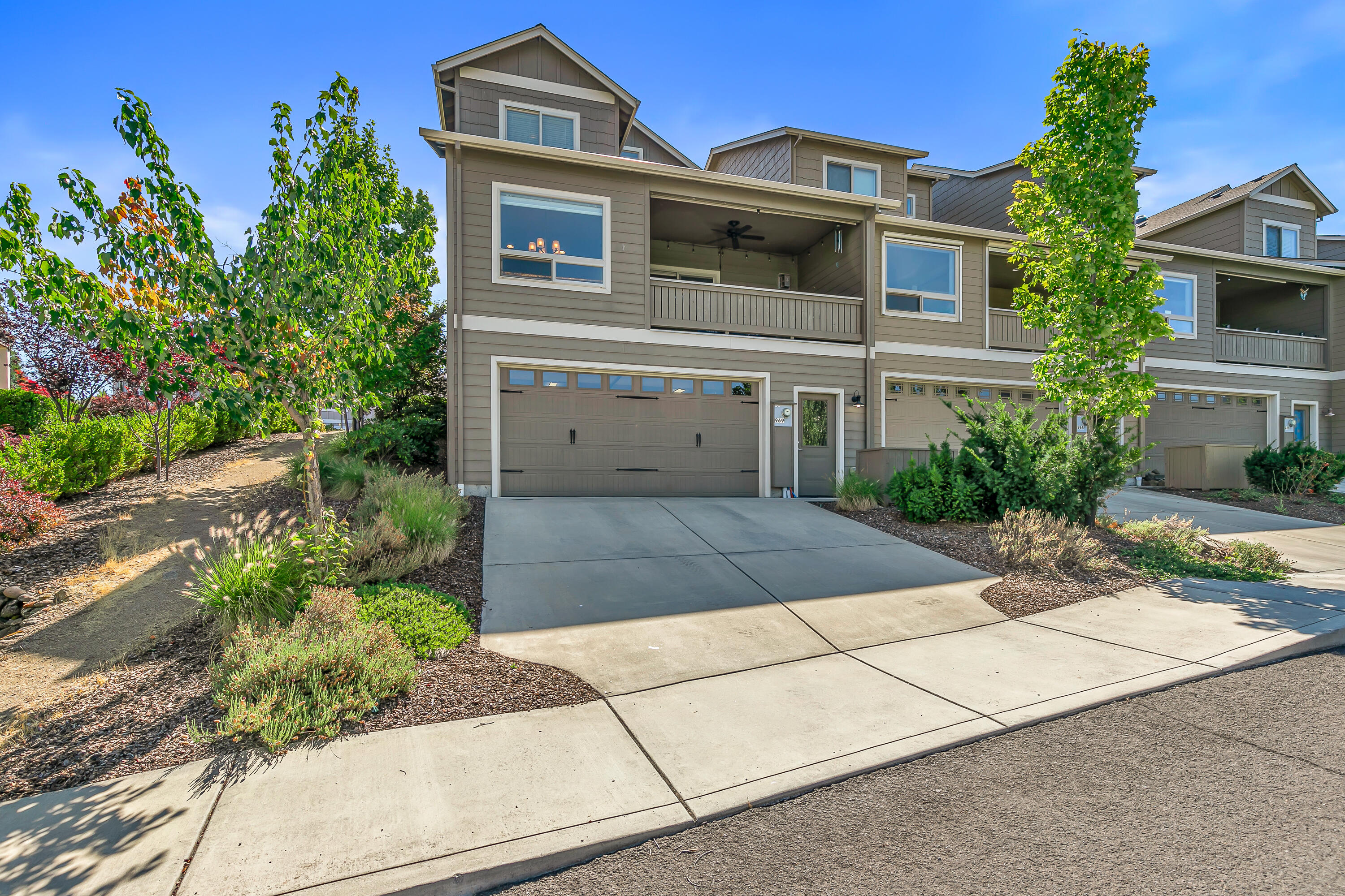 Turn-key end unit townhome with exceptional sunsets, valley, and mountain views within a four-minute walk to dog-friendly Kestrel Park! Kitchen with tiled backsplash, cabinets with custom pull-outs, granite dining island, stainless sink, and Frigidaire Gallery appliances including four-burner induction cooktop. Adjacent dining area surrounded by windows, living room with sliding glass door to covered view balcony with ceiling fan, powder room, coat and laundry closets. Main level primary suite with ceiling fan, walk-in closet, and full ensuite bathroom with granite vanity, double vessel sinks, and tiled shower. Two vaulted upper-level bedrooms - one with walk-in closet - and full bath with granite vanity, vessel sink, and tub shower with tiled surround. Lower level with oversized two-car garage and two large storage closets. Elevator-ready floor plan. Front yard and adjacent common area with mature trees and plantings maintained by minimal association dues. Inquire for details!
