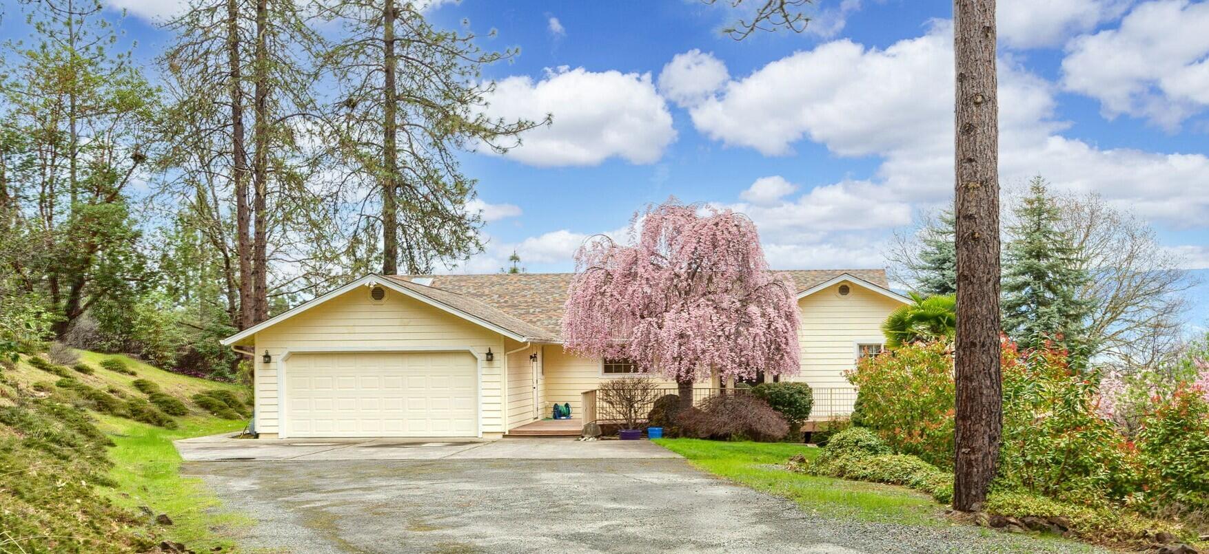 SELLERS MOTIVATED-ANOTHER PRICE REDUCTION of $50,000! -come take a look   at this lovely well built home featuring 3 bedrooms, 3 baths totalling 2,768 sq.ft.  Downstairs is a big bonus room as well as one of the bedrooms and baths with its own separate entrance.  In addition to the attached 2-car garage, there is another huge detached multi-use separate garage (36' x 40') all located on a lovely 5-acre lot.  Many custom features - jacuzzi tub and separate shower in primary bedroom, skylights, separate storage/mudroom with exterior entrance, stone fireplace w/propane insert*(see comments) surround sound, tons of storage throughout home, custom knotty pine vaulted ceilings, central vac.  Beautiful landscaping, large fenced garden area, trex decking with railing, lovely views of surrounding mountains, close in to town.