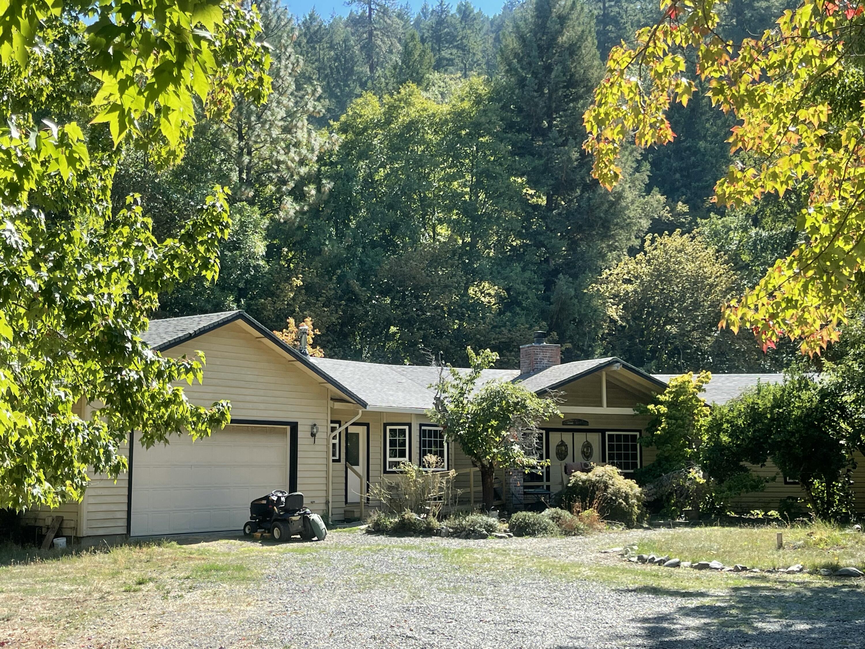 Southern Oregon's Applegate Valley offers the ultimate horse lover's dream on nearly 20 acres bordered by BLM and Thompson Creek. A tree-lined drive leads to a 2,413 sq ft ranch-style home, custom built in 1995 and lovingly maintained. Inside, enjoy beautiful open-beam ceilings in the living and sun rooms, 9-ft ceilings throughout, a kitchen with tile counters and floors, and a master suite with jetted tub and walk-in closet. The equestrian facilities are a true standout—an expansive covered arena, a 40x48 barn with 5 stalls, 4 fenced and cross-fenced pastures, and a small pond. The property also boasts a 40x75 shop, gated entry, and stunning mountain views. With EFU zoning, 30 GPM well when drilled (per previous owner), 14 acres of irrigation rights, and direct access to BLM land, this estate offers both functionality and rural beauty. Add in wonderful neighbors and you have the perfect blend of comfort, privacy, and country lifestyle.