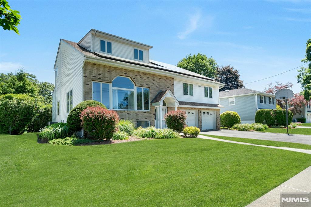 Located just 1 block to Milnes Elementary & TJ Middle School, this exceptional 5BR home with over 3500sf offers an impressive combination of design and functionality. Upon entering you will be captivated by the magnificent living room with soaring ceilings, abundant recessed lights and large windows that illuminate the room, grand bookcase, hardwood flooring and 600+sf of versatile space that flow seamlessly into the dining room. The huge granite kitchen features abundant cabinetry, dual islands, sinks, ranges, dishwashers and a spacious dining area. A bonus is the auxiliary kitchenette that makes holiday prep a breeze. The 2nd floor hosts 3 spacious bedrooms, including the original primary with ensuite bath, ample closets and hardwood floors. Ascend to the 3rd floor to find a wonderful primary suite with vaulted ceiling, substantial walk-in-closet and bath with double vanity and separate tub & shower. A 5th bedroom on this level is perfect as an office, nursery or gym. A spacious ground level den with well-crafted built-ins provides convenient access to both the yard and 2-car garage and has a lovely powder room. Enjoy terrific additional living space in the expansive finished basement that offers an updated full bath & multiple recreation, office or guest rooms. This energy efficient home includes cost-saving solar panels (owned). Roof (approx. 7 years), 4-zone heat/2-zone central air, alarm system. Prime location near NJ transit express bus & houses of worship.